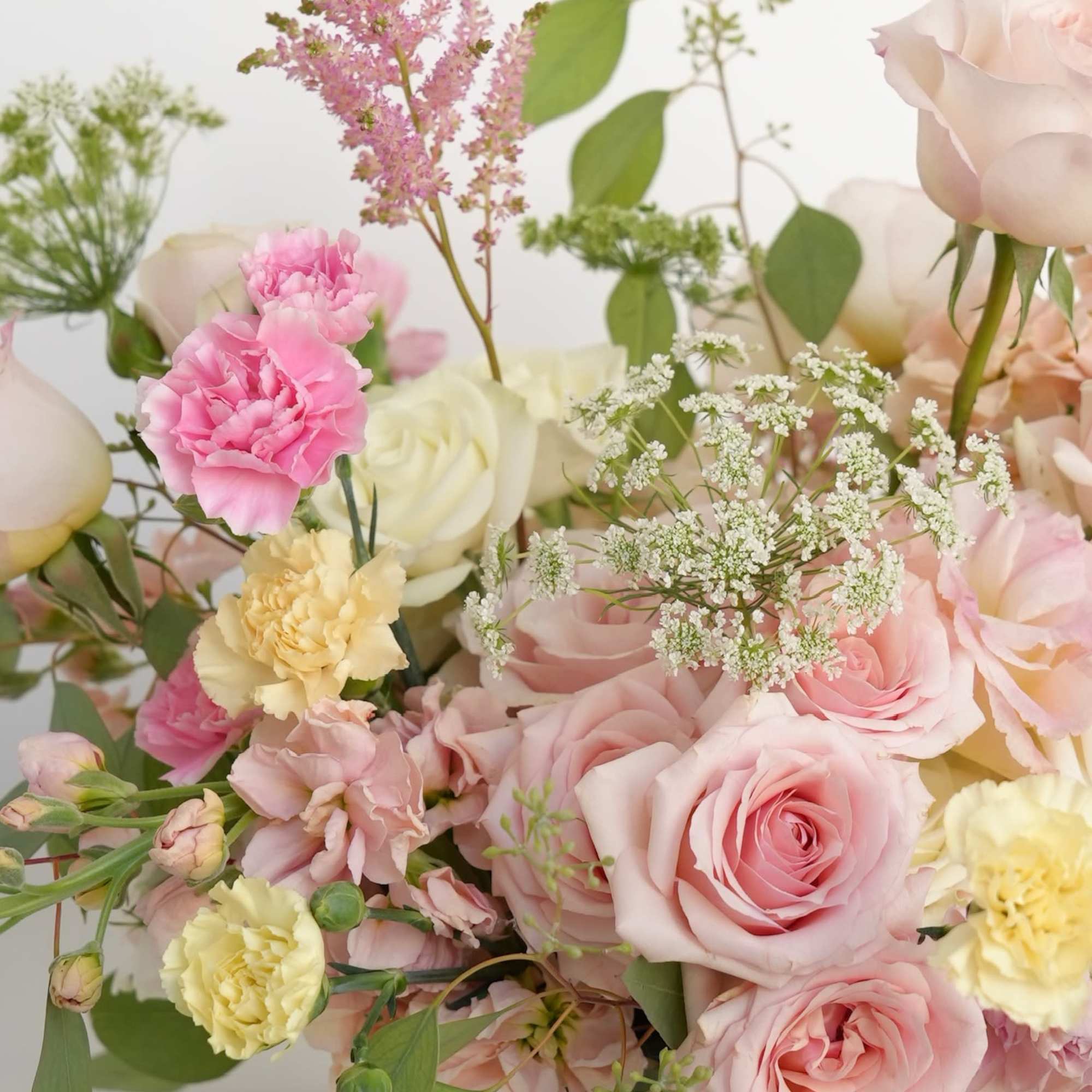 A lush floral arrangement displayed in an elegant golden vessel with soft A lush floral arrangement displayed in an elegant golden vessel with soft