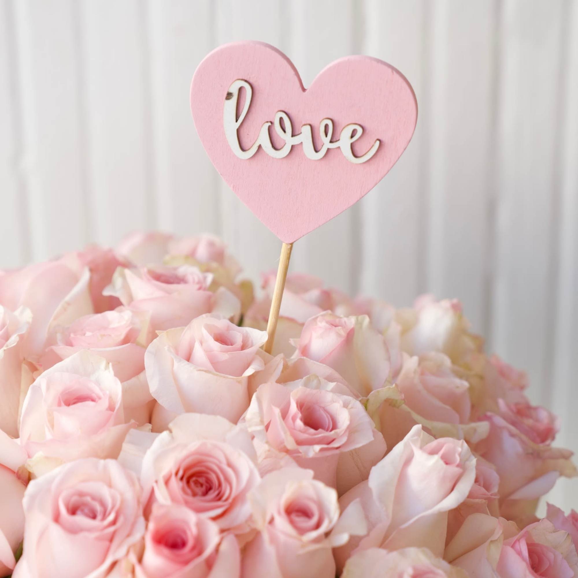 This bouquet of soft pink roses in a pink vase is the This bouquet of soft pink roses in a pink vase is the