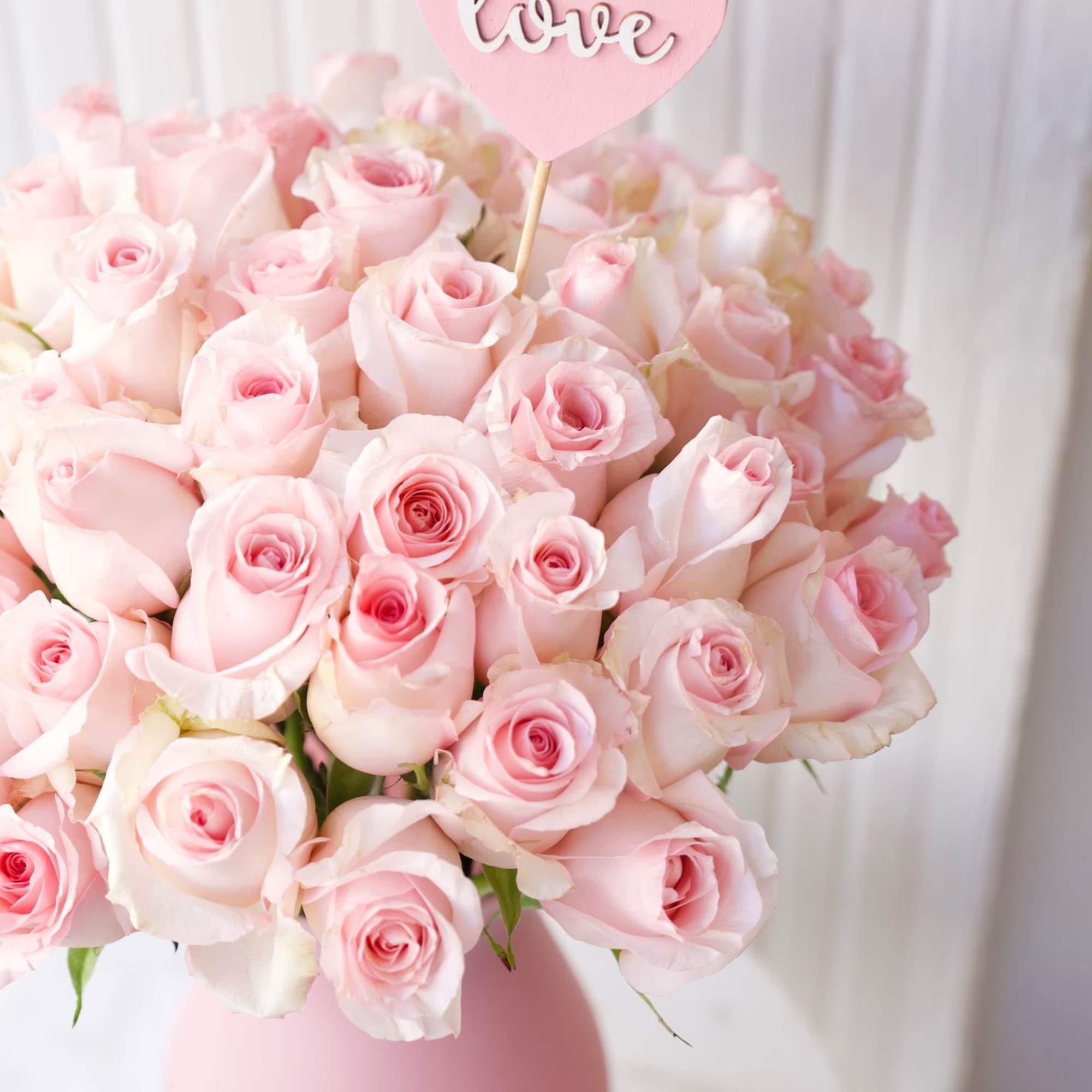 This bouquet of soft pink roses in a pink vase is the This bouquet of soft pink roses in a pink vase is the