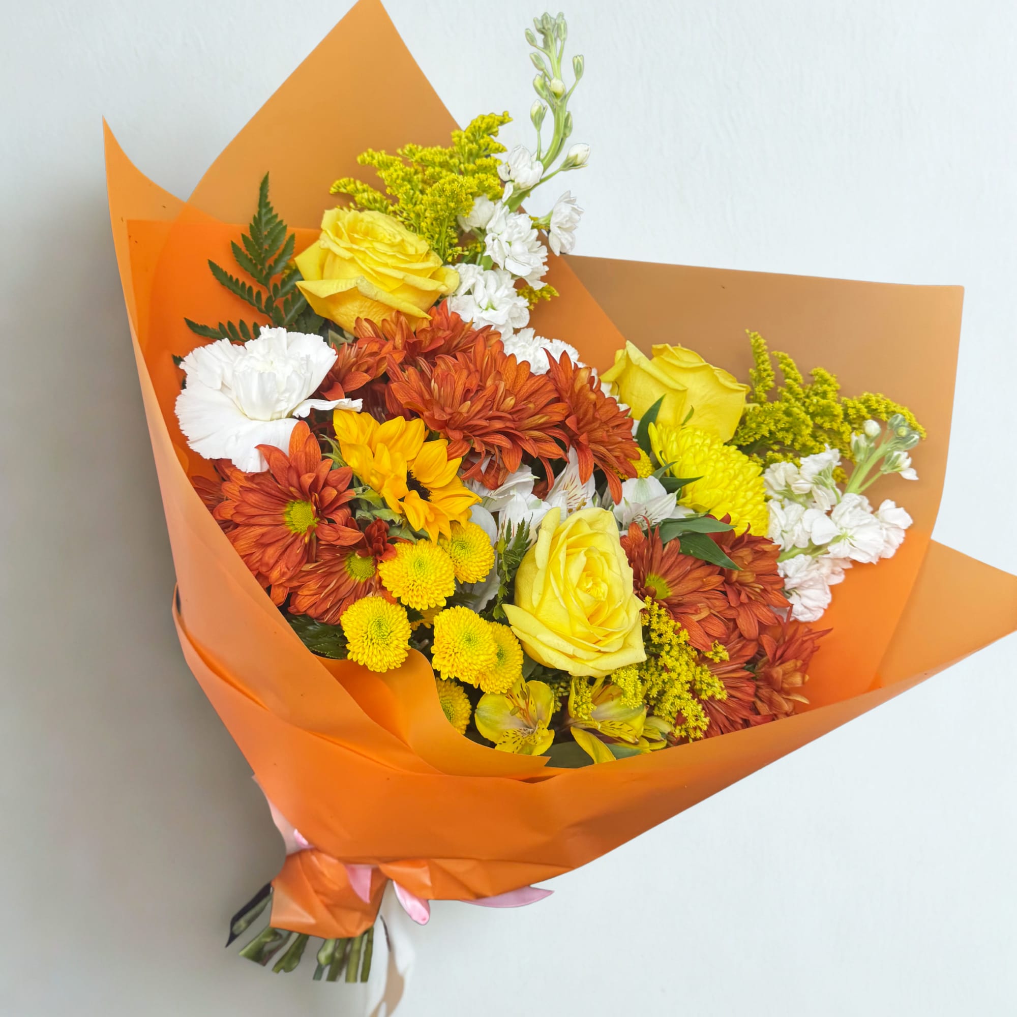 A warm and vibrant bouquet inspired by autumn sunsets. Featuring yellow roses