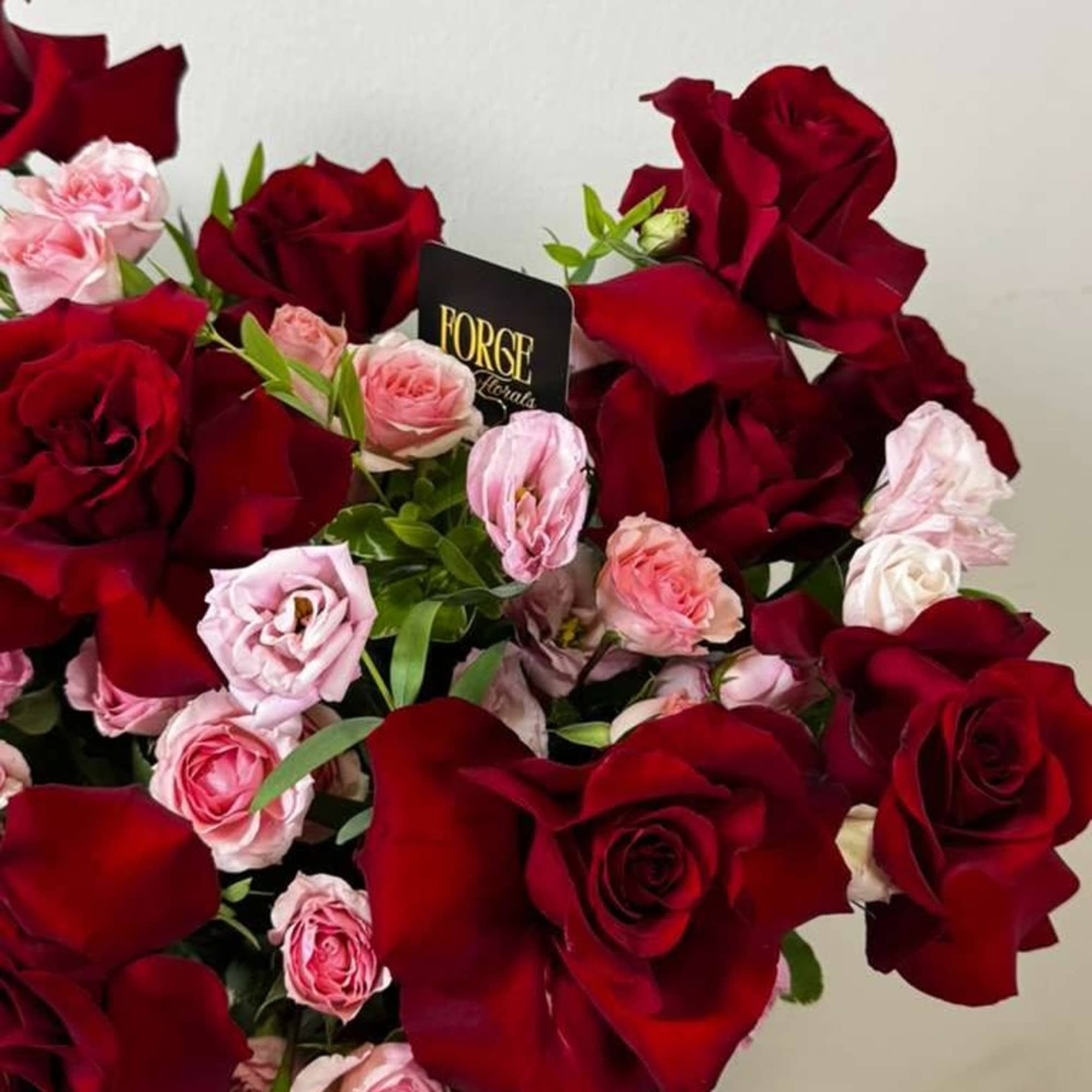 French red roses paired with delicate pink mini roses in a sleek