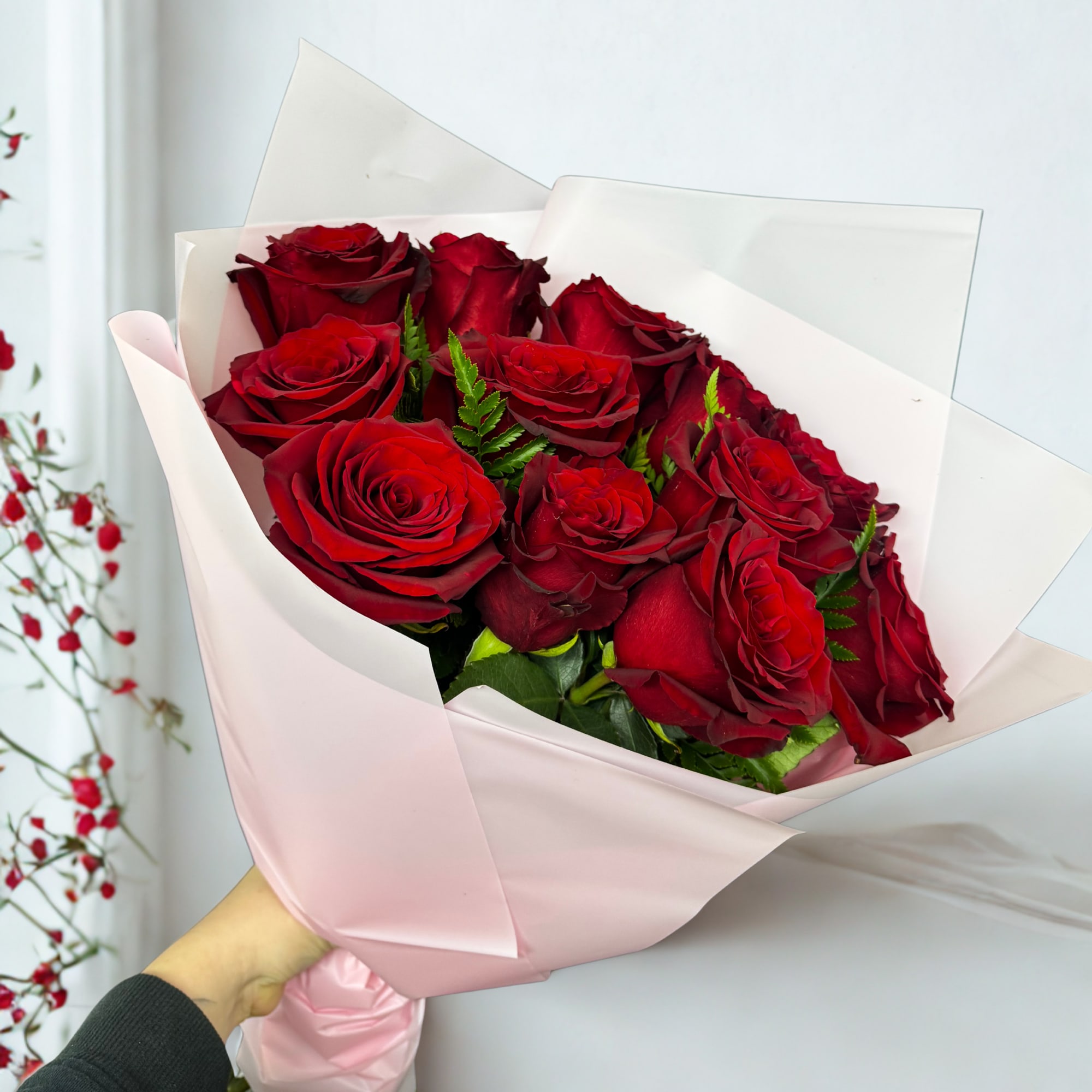 A timeless bouquet of 12 velvety red roses, wrapped in soft blush