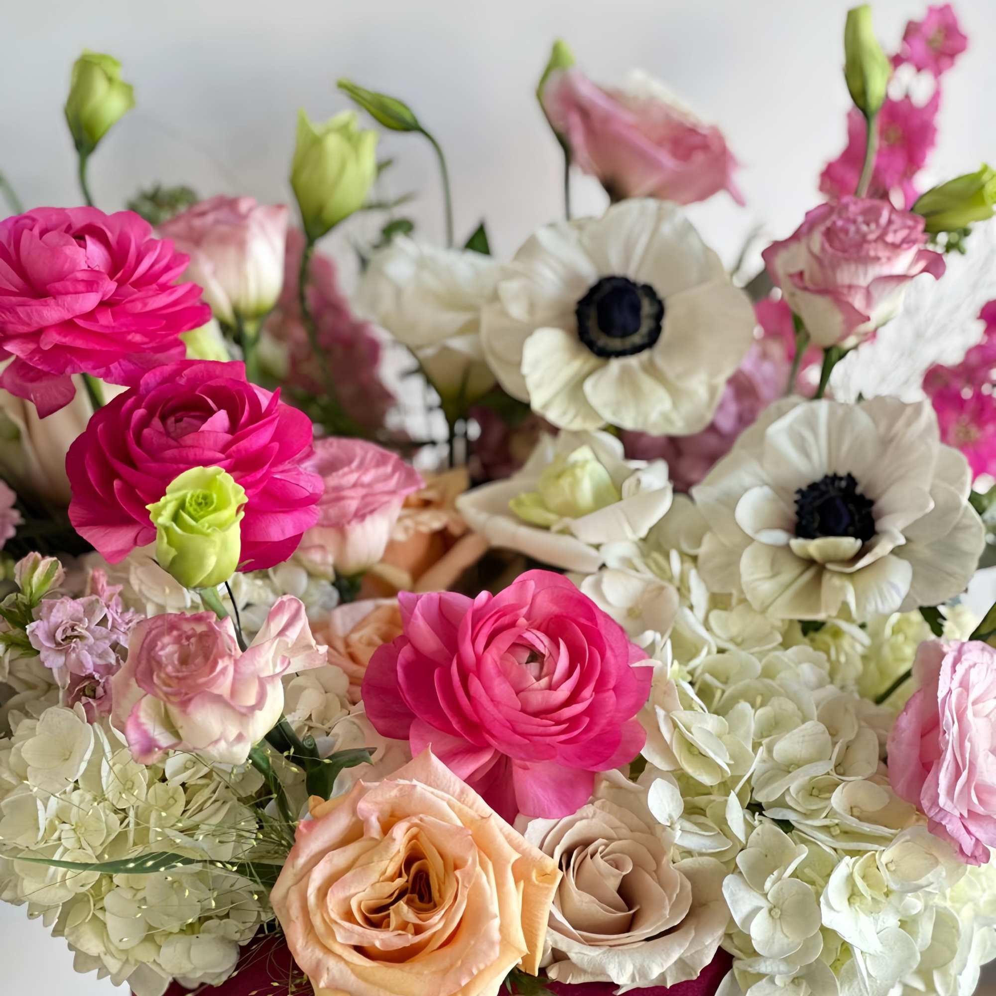 Burgundy velvet box with peach, white, and pink flowers. A delicate and