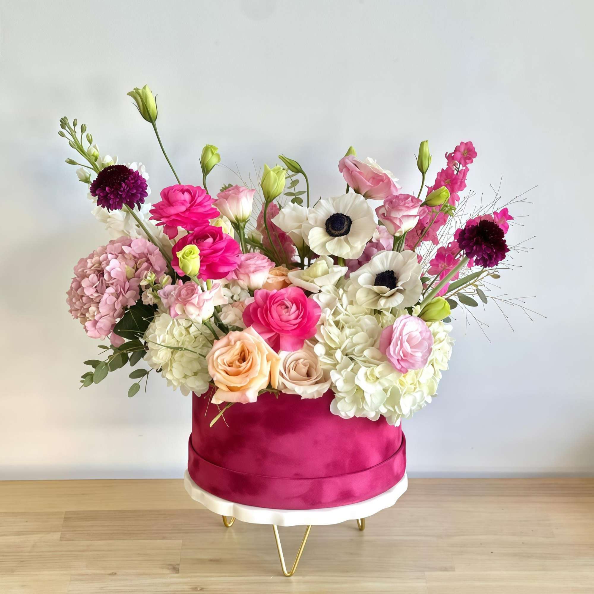 Burgundy velvet box with peach, white, and pink flowers. A delicate and