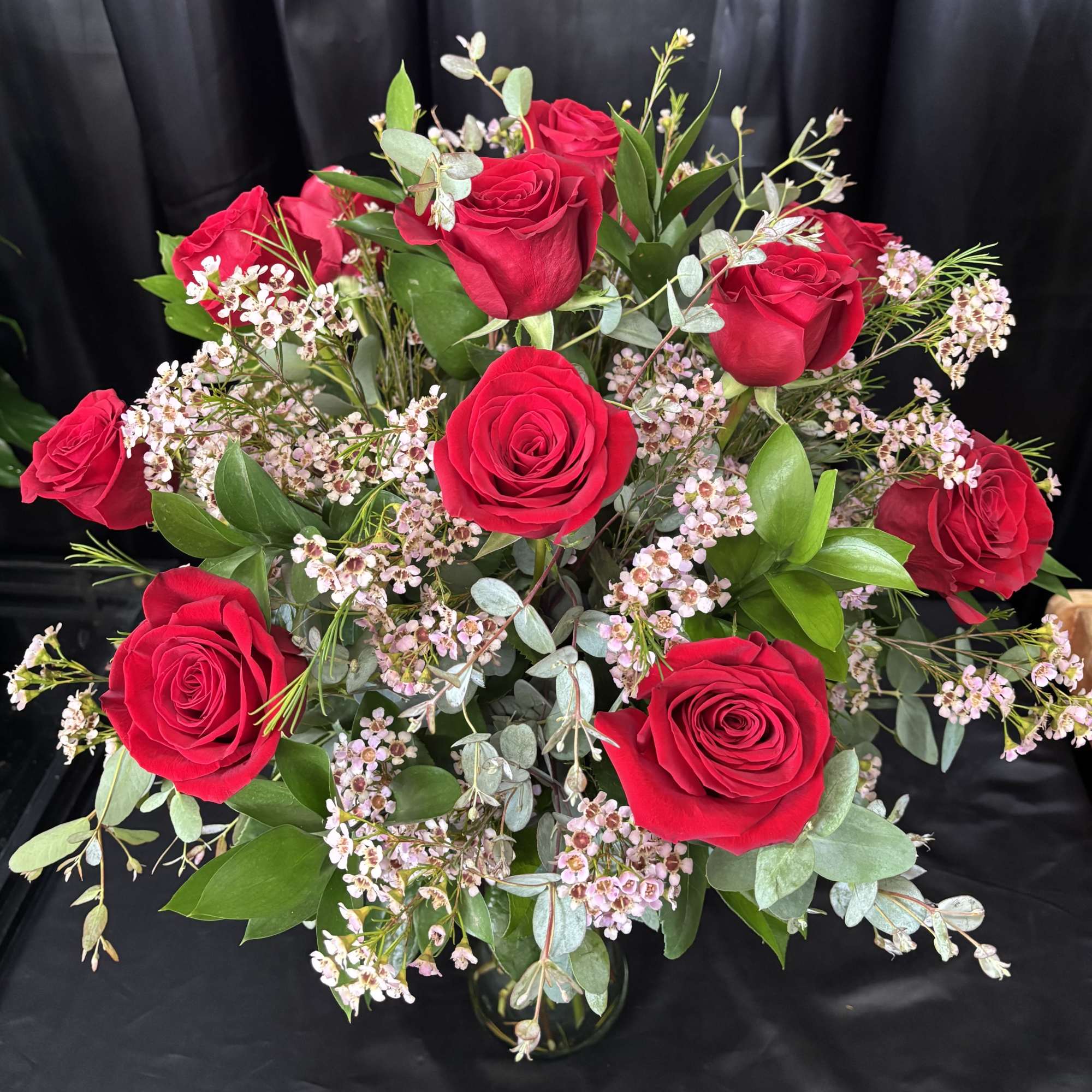 1 Dozen of our beautiful long stem roses arranged with premium greens