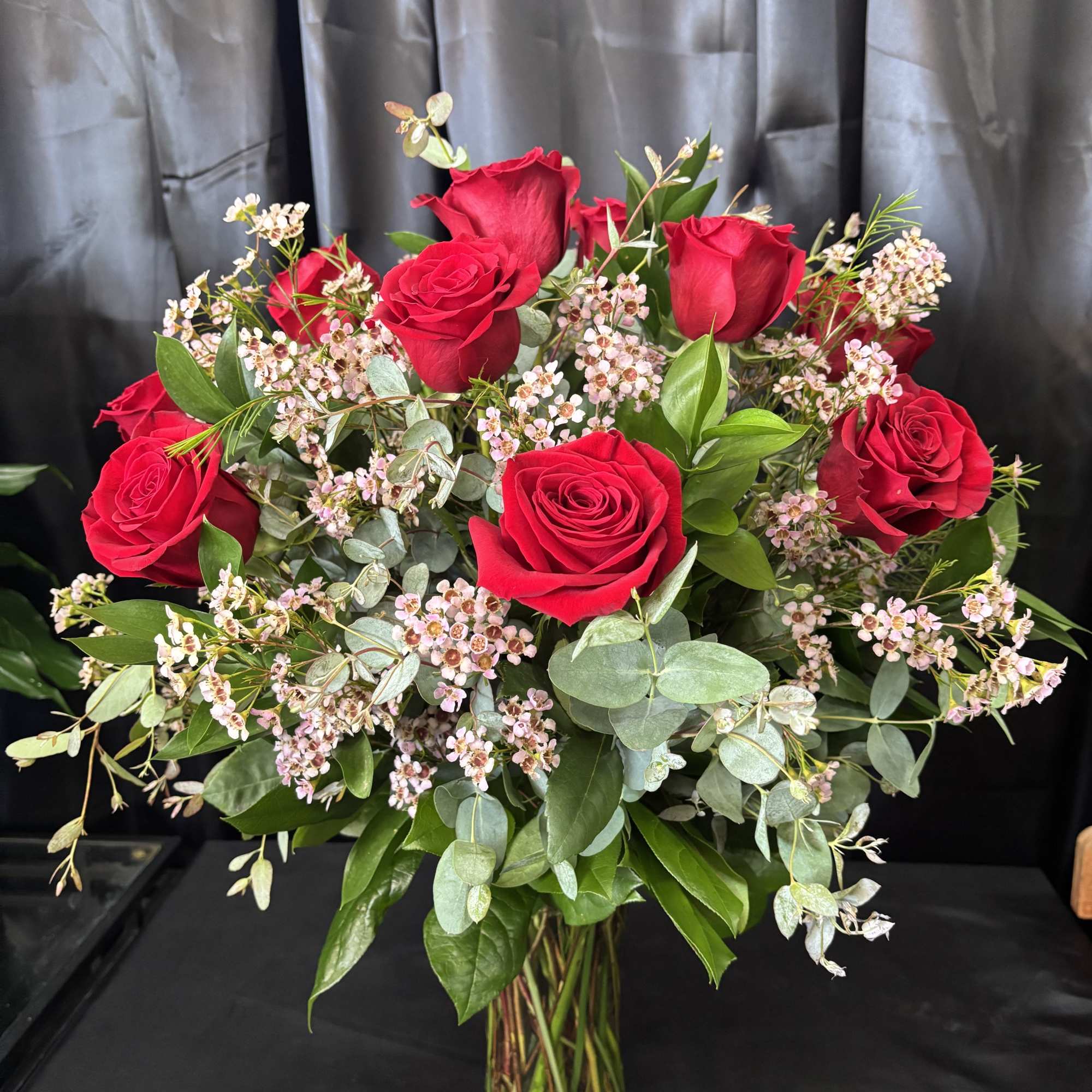 1 Dozen of our beautiful long stem roses arranged with premium greens