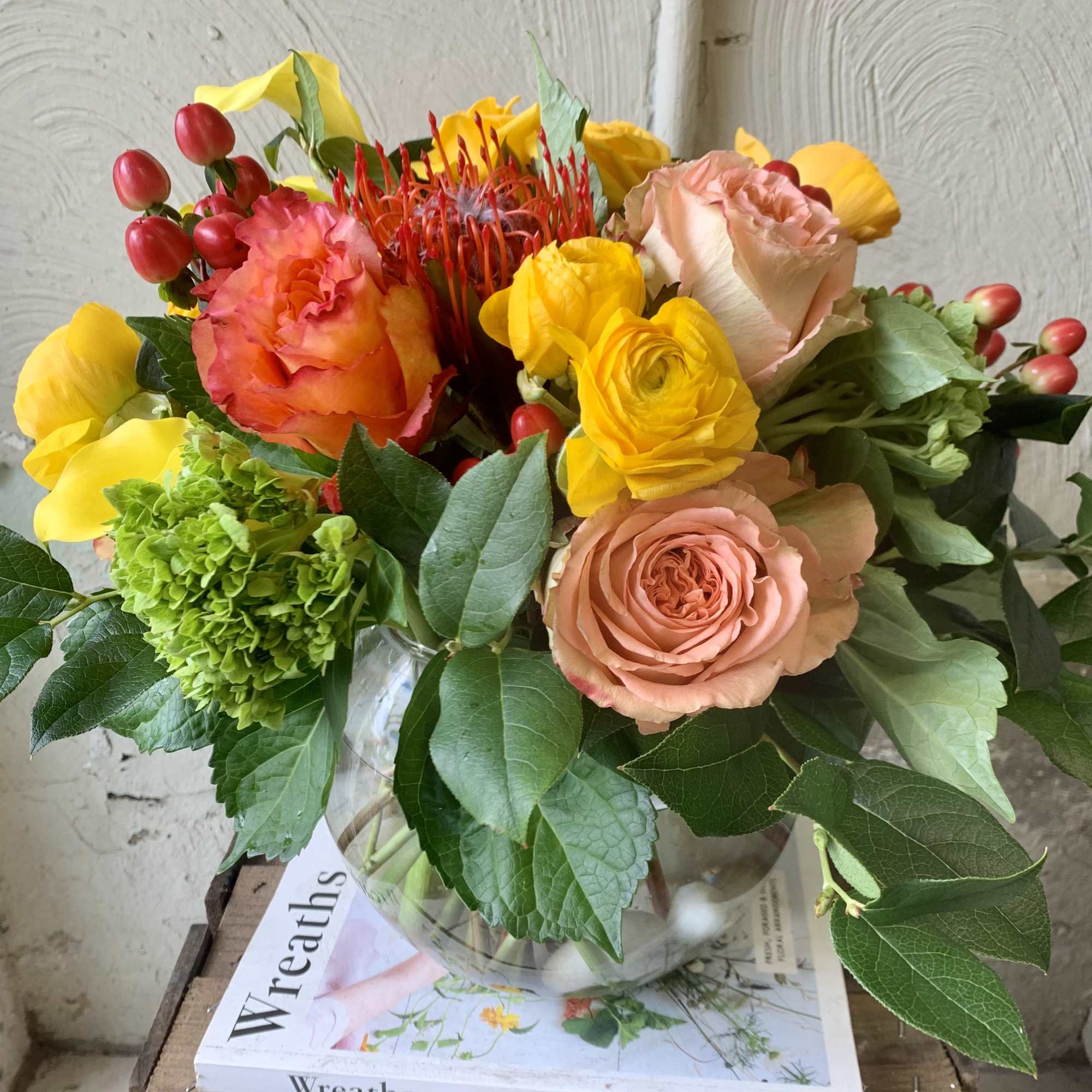 An autumnal vibe of reds, oranges and yellow florals of ranunculus, roses