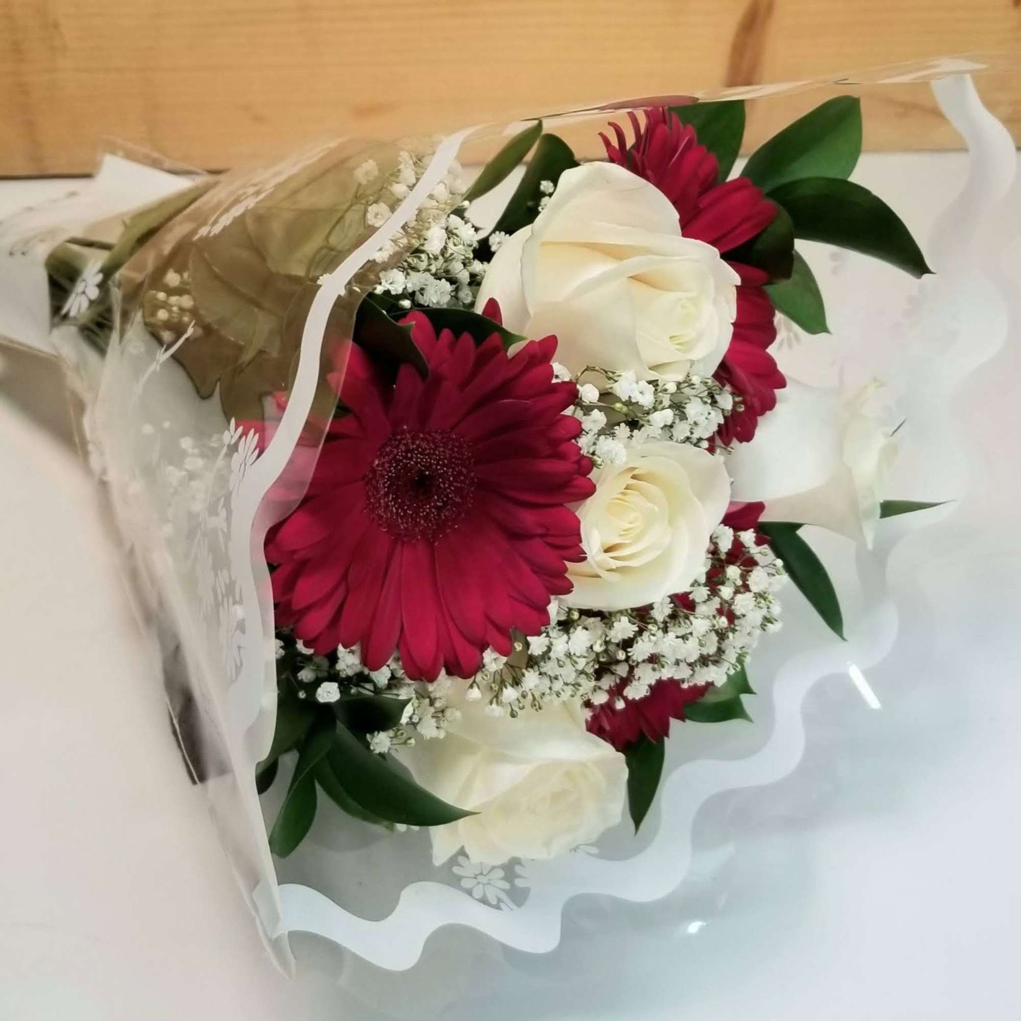 The GO OP Wrapped Rose & Gerb Bouquet by Savilles Country Florist. The GO OP Wrapped Rose & Gerb Bouquet by Savilles Country Florist.