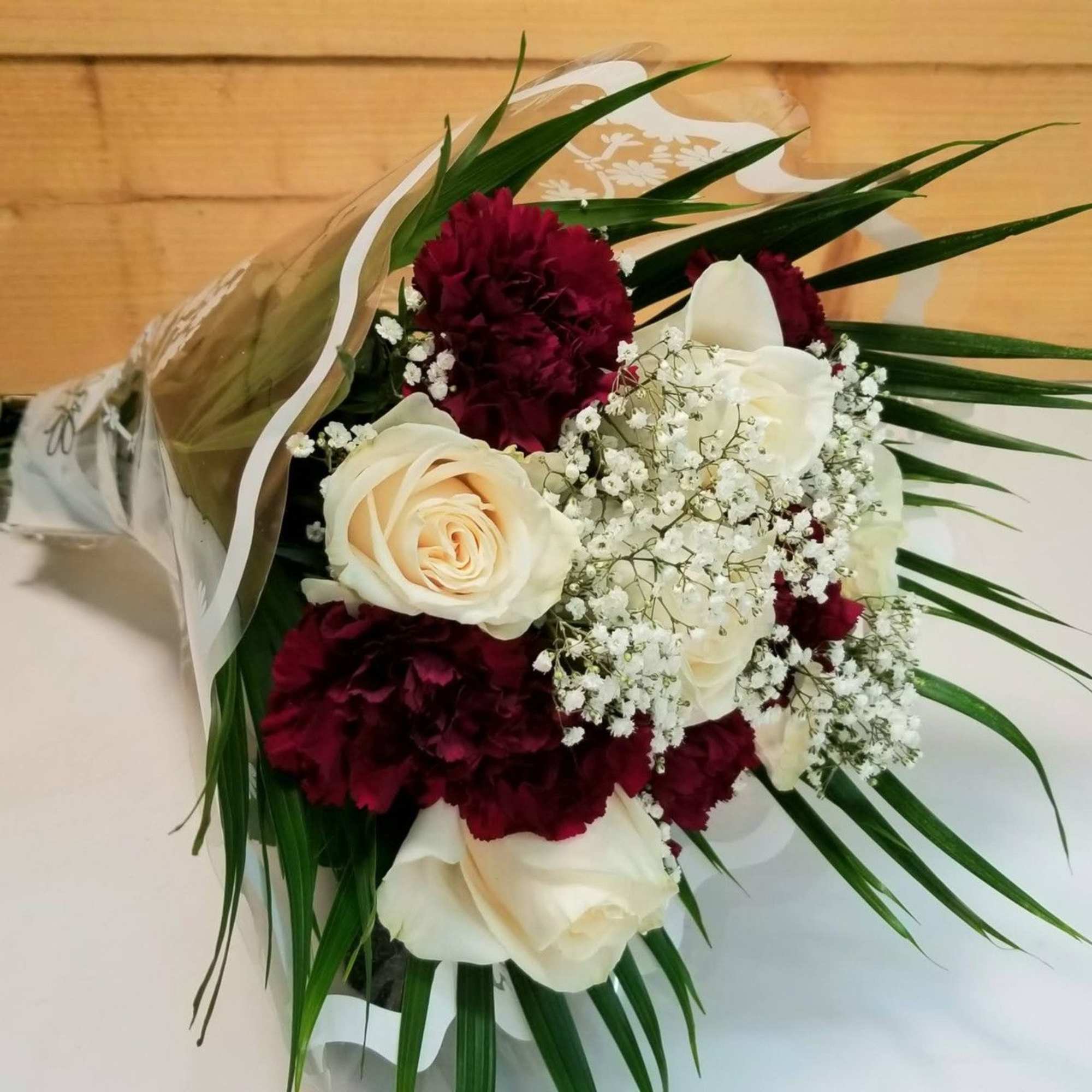 The GO OP Wrapped Rose & Carnation Bouquet by Savilles Country Florist. The GO OP Wrapped Rose & Carnation Bouquet by Savilles Country Florist.