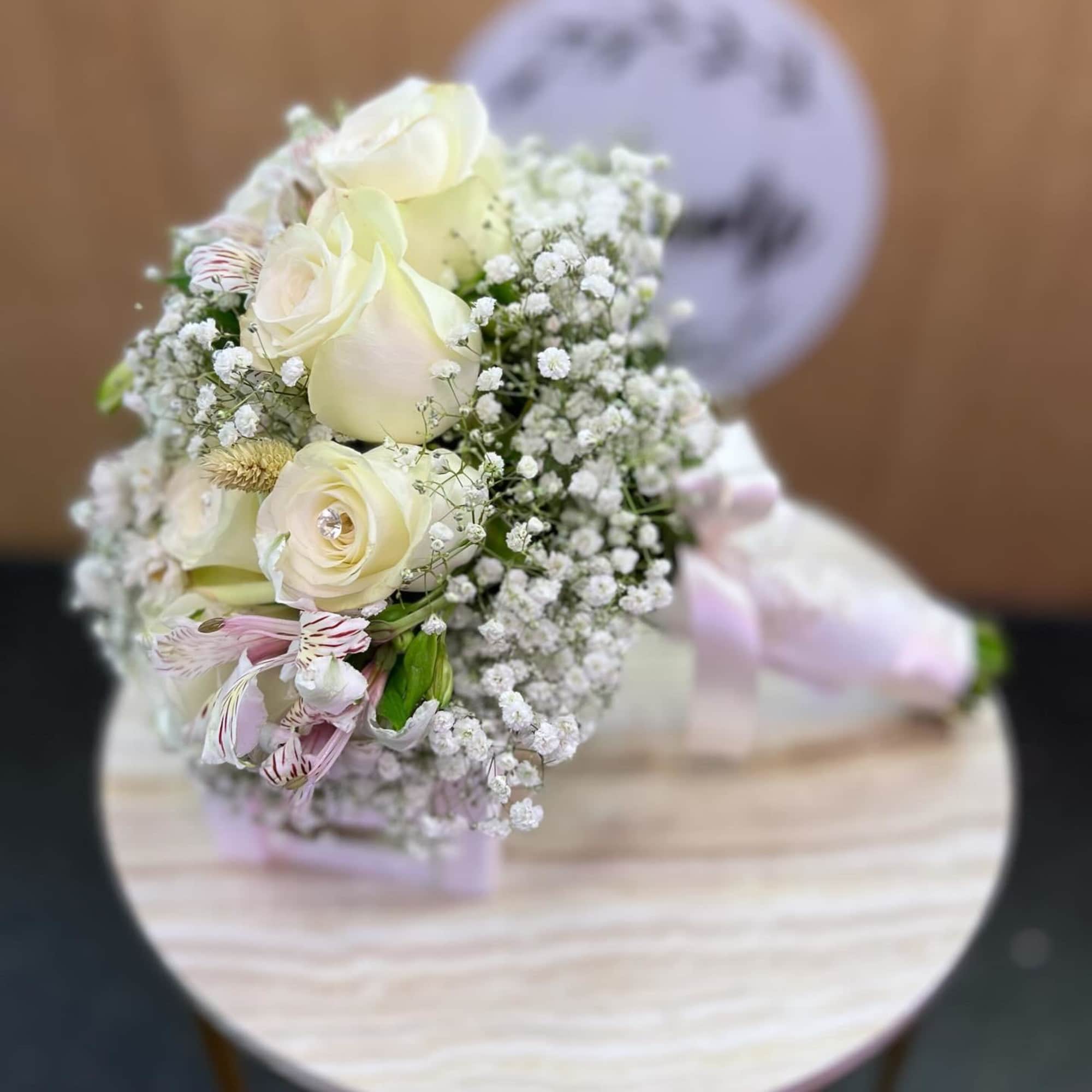 A classic white rose bouquet hand tied with ribbon. The perfect accessory