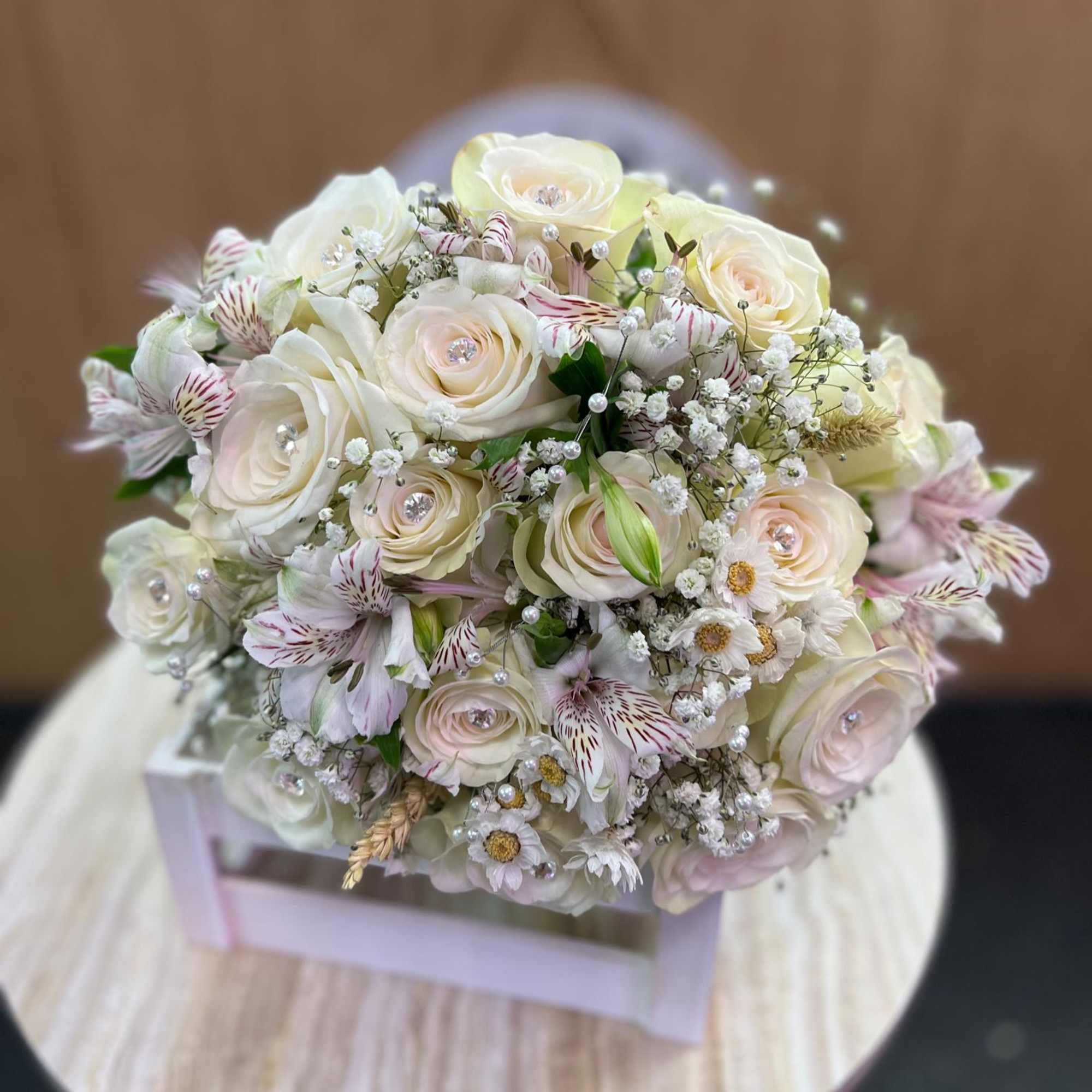 A classic white rose bouquet hand tied with ribbon. The perfect accessory