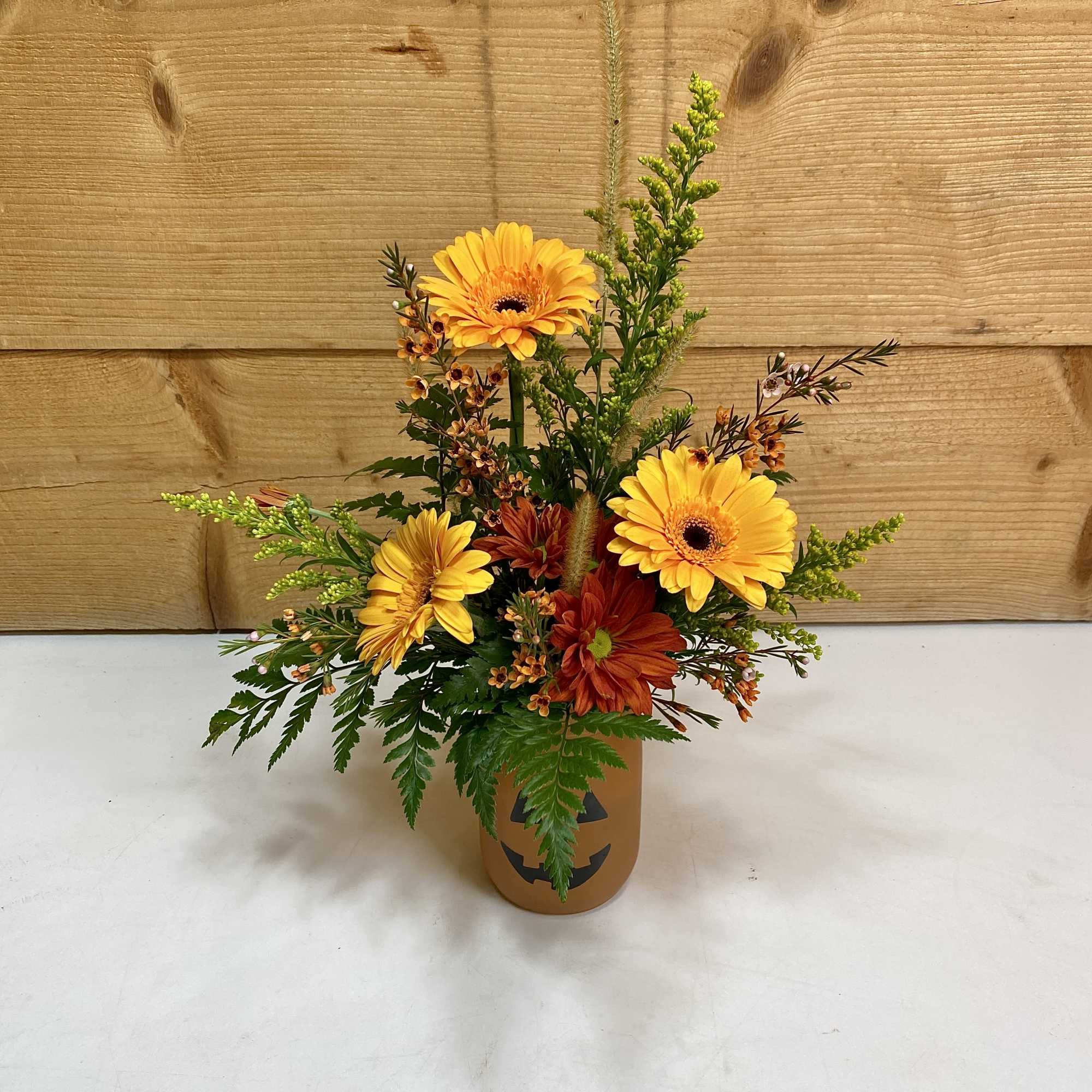 Classic Halloween cheer meets fall floral beauty. Bright orange and golden blooms Classic Halloween cheer meets fall floral beauty. Bright orange and golden blooms