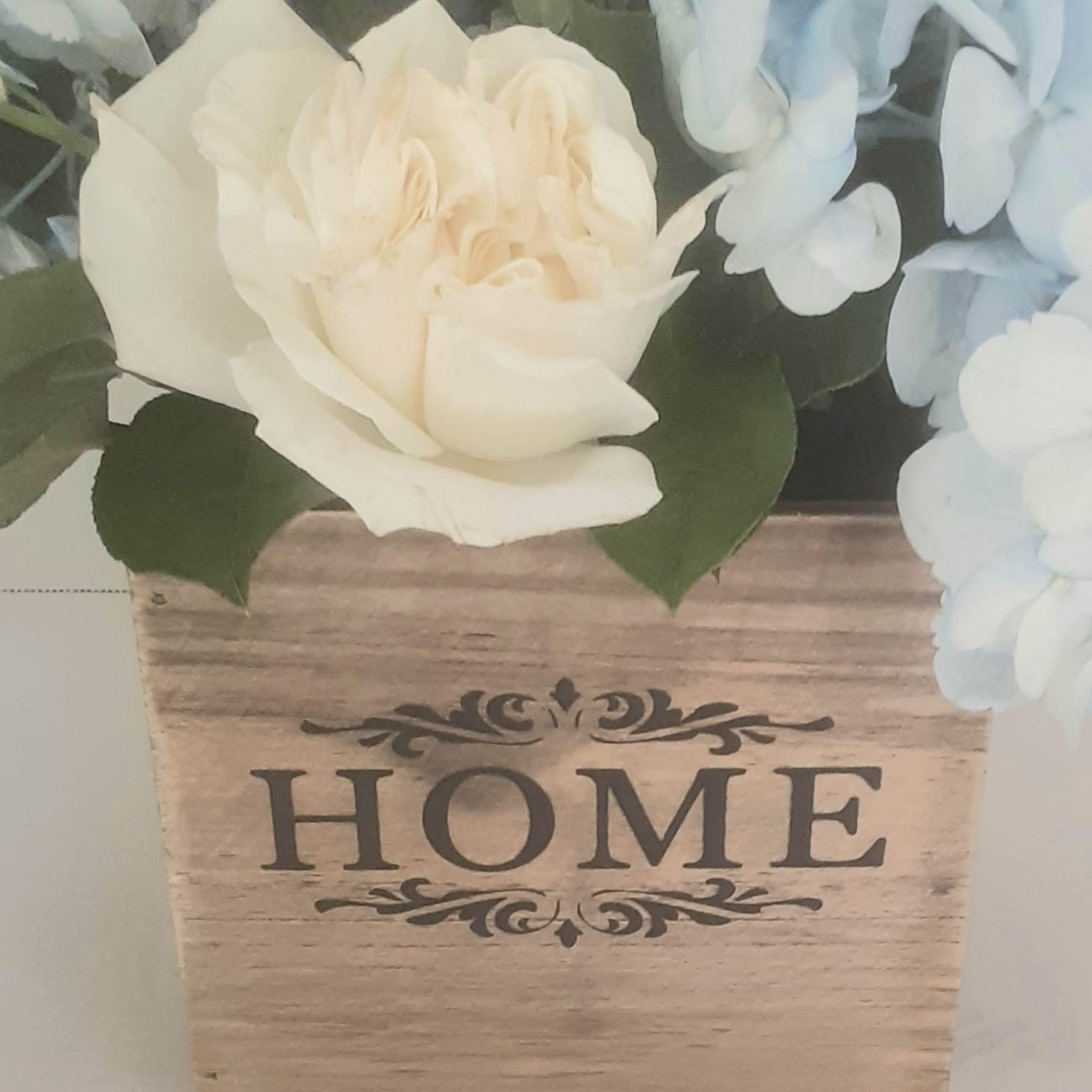 Arranged beautifully in a modern all wood cube,with white roses, blue delphinium