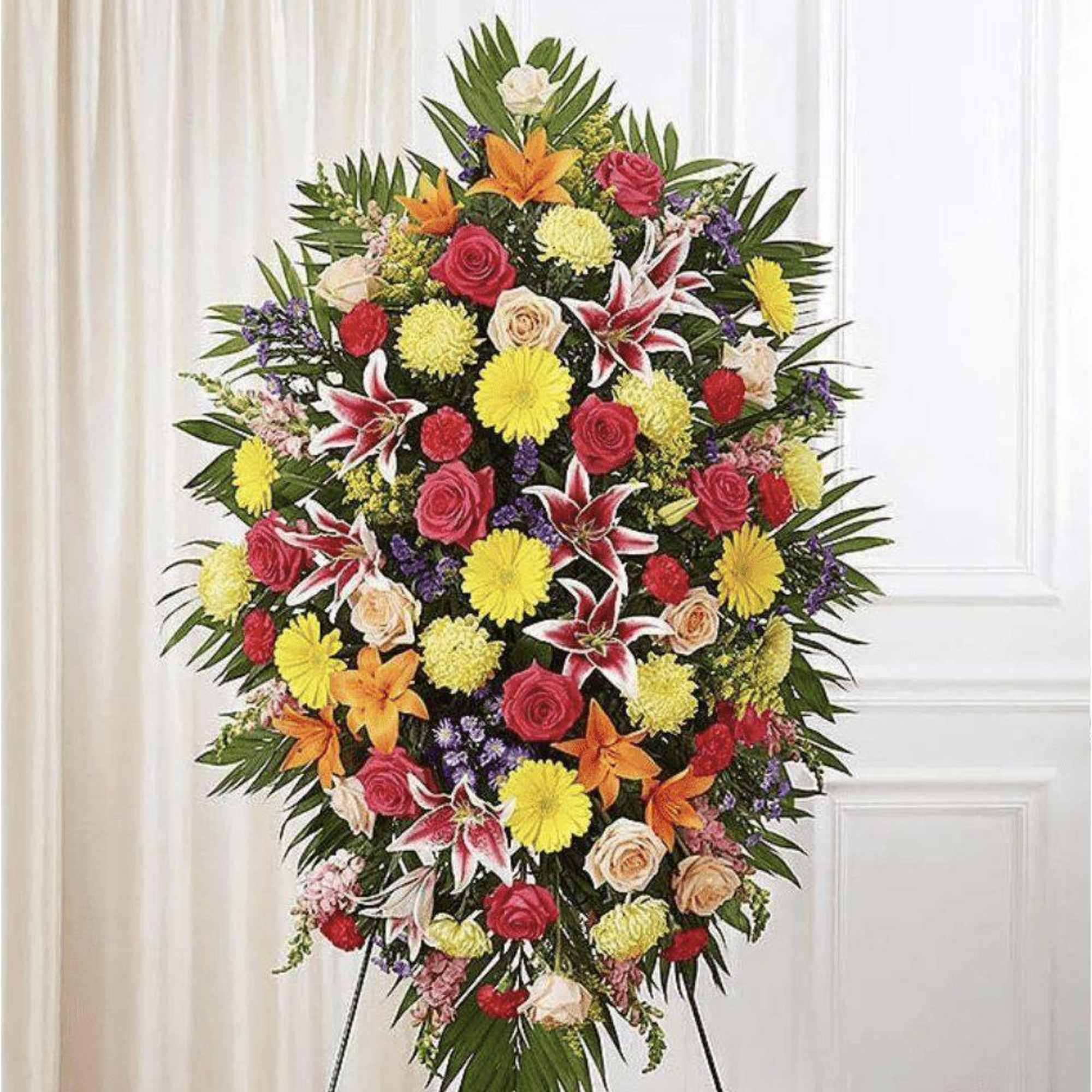 Send your sympathy with a colorful and bright floral oval standing spray.