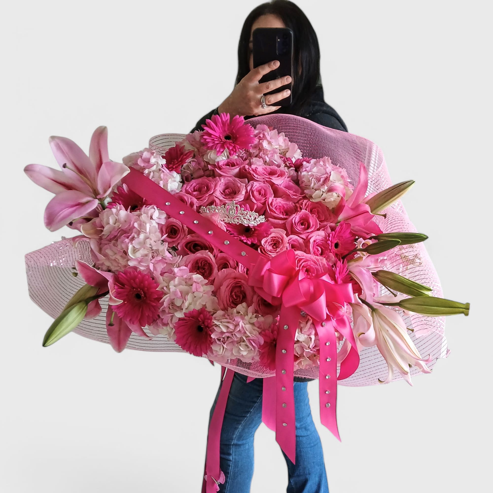 Stunning and pink with roses hydrangeas daisies lilies and a rhinestone tiara.