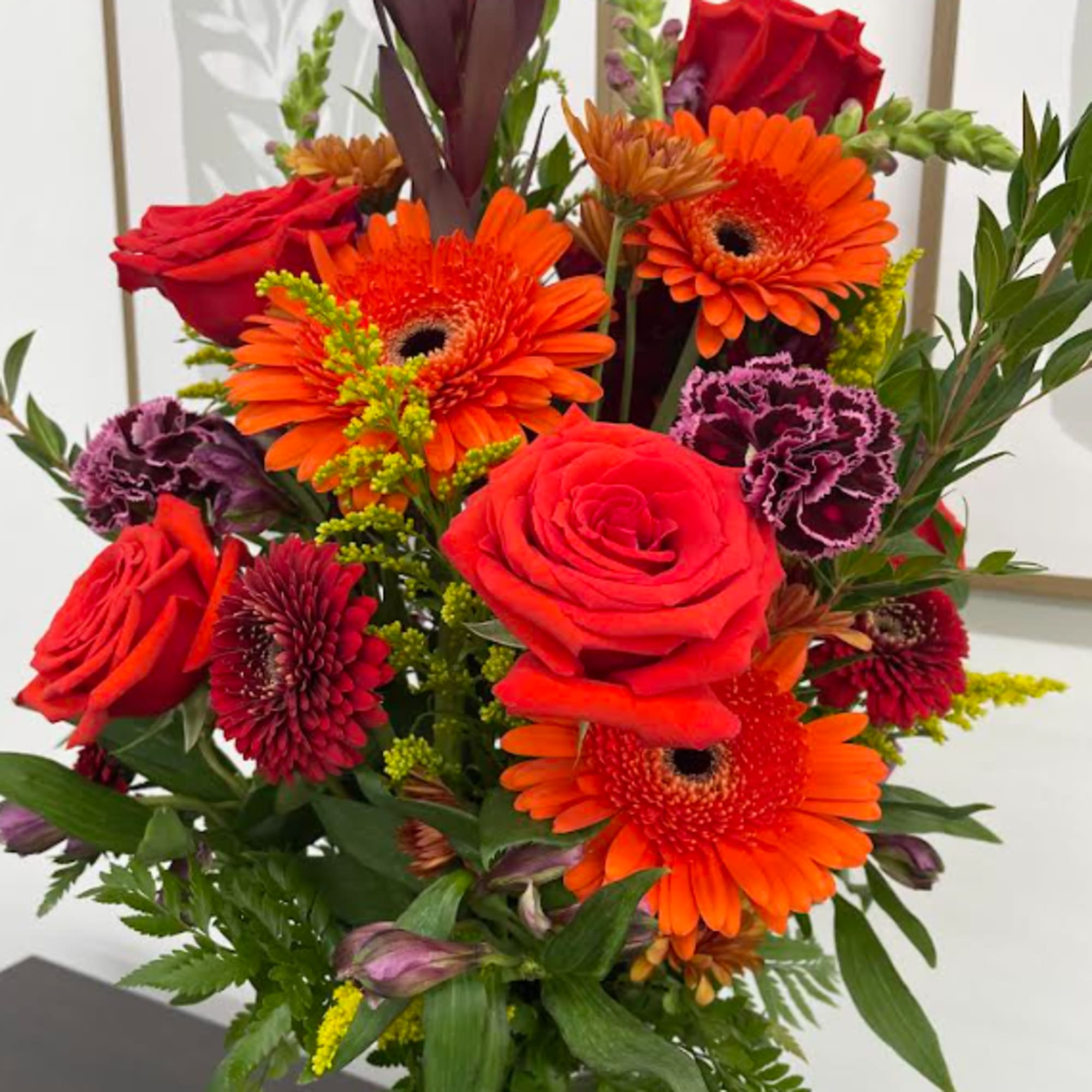 A vase full or bright orange flowers.  Sure to bring a