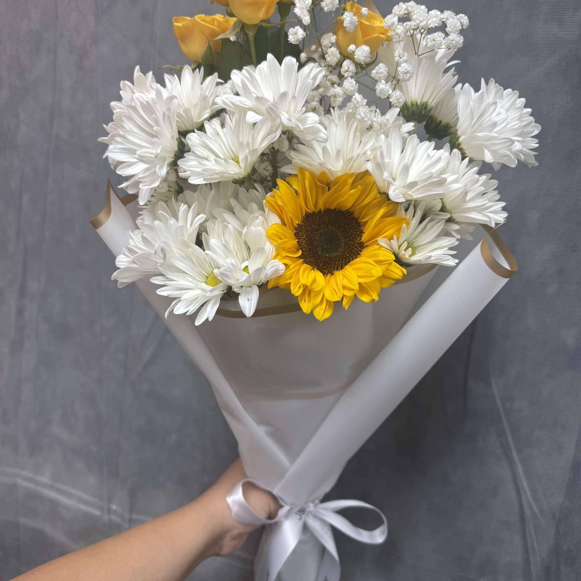 A cheerful hand-tied bouquet of bright sunflowers and sweet white daisies &mdash;