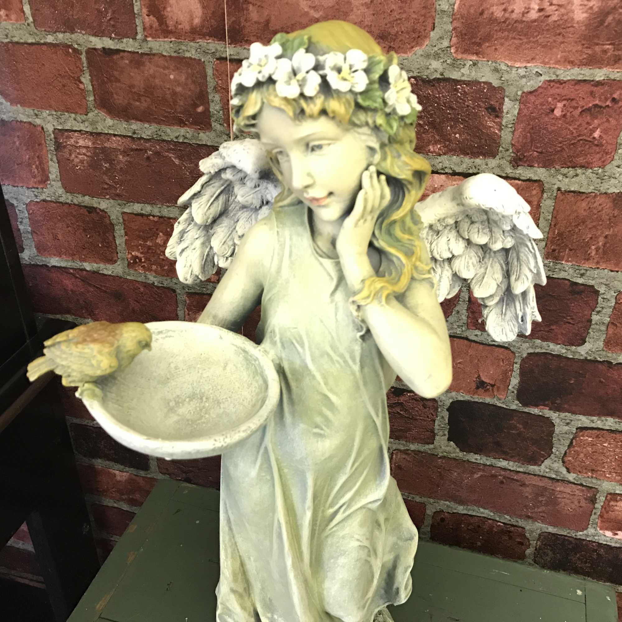 Wonderfully detailed resin angel of a standing angel holding a birdfeeder. If