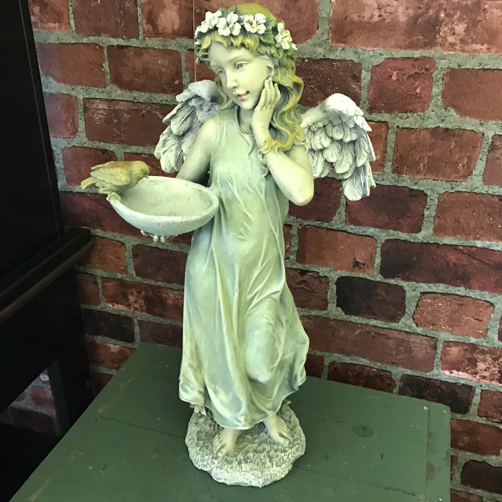 Wonderfully detailed resin angel of a standing angel holding a birdfeeder. If