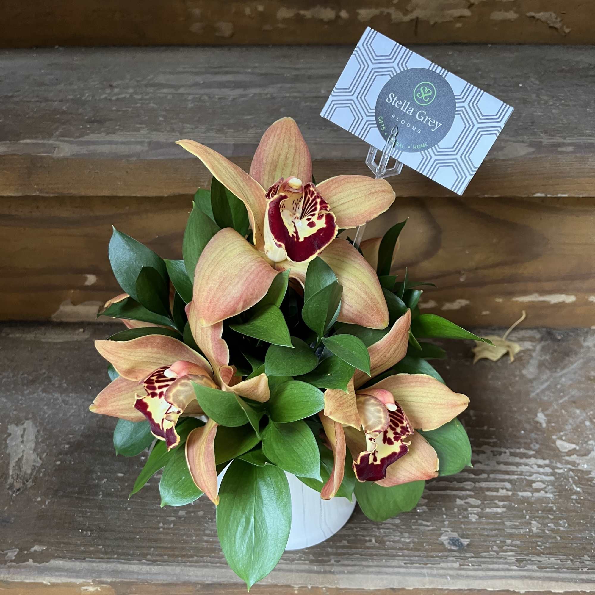 5-6 Cymbidium Orchids and hearty greens is a marble vase.  Perfect