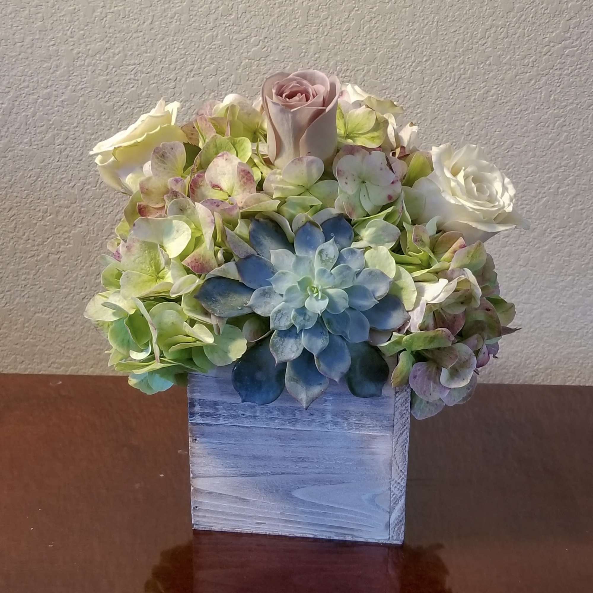 A refined mix of soft blooms and a sculptural succulent creates an