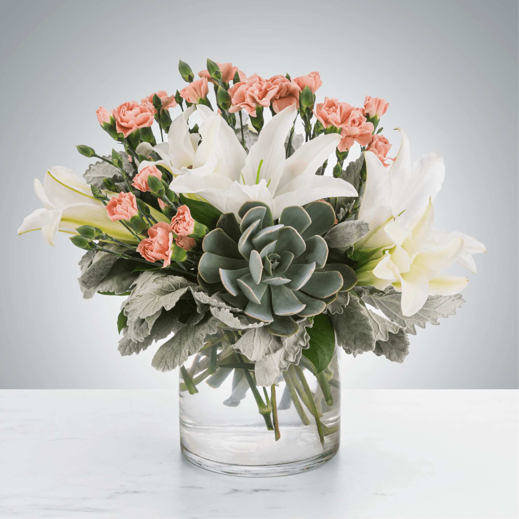 A refined mix of soft blooms and a sculptural succulent creates an