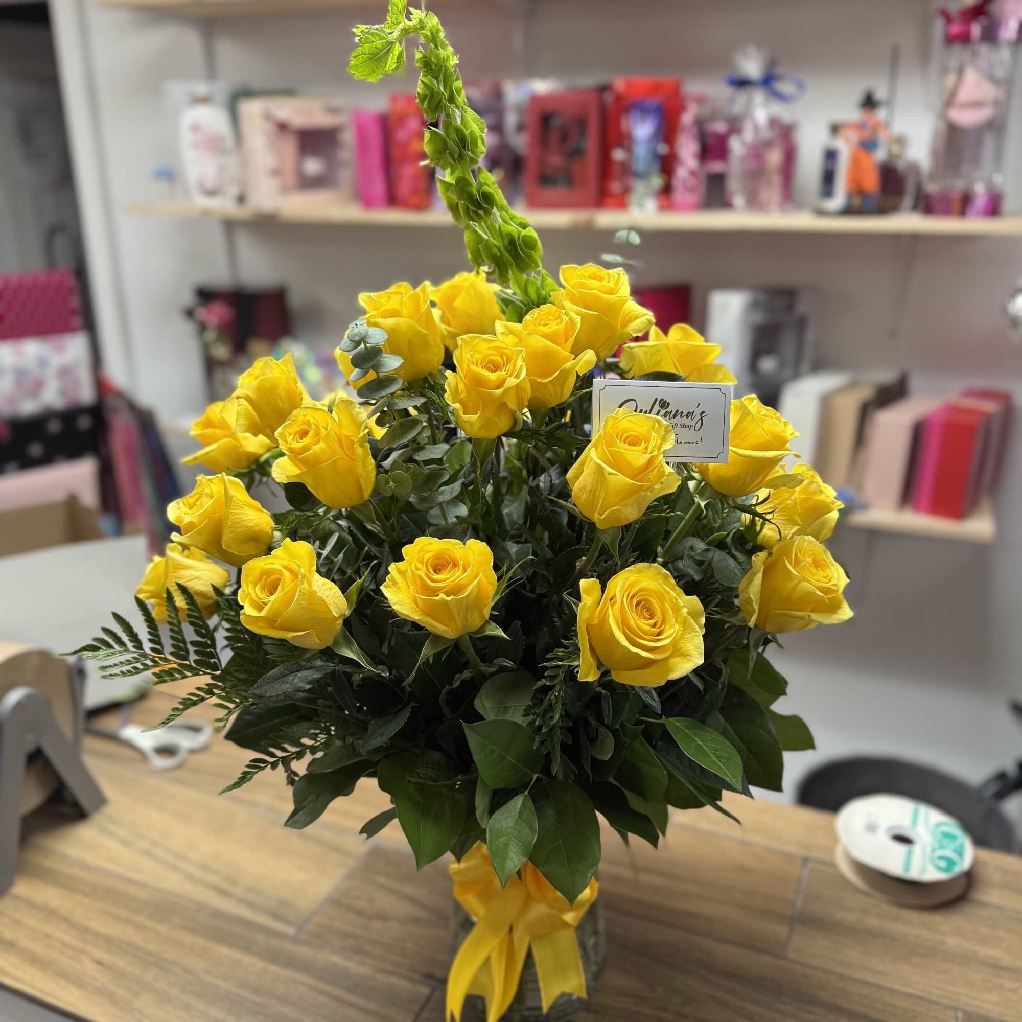 Glass vase with a 25 Yellow roses  and fine foliages. 
