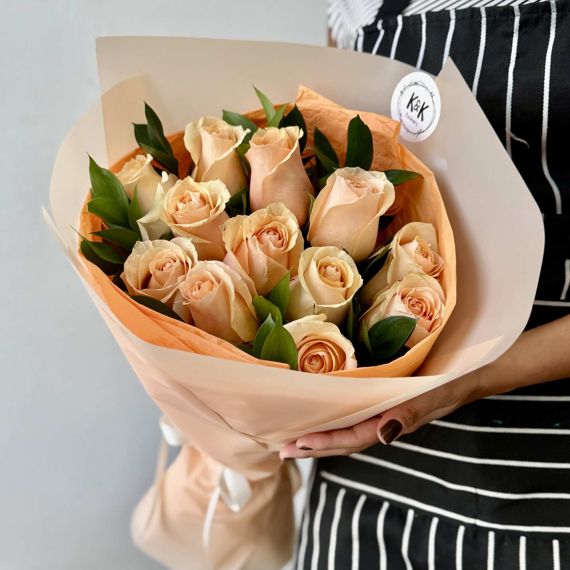 Peach Roses with greenery and decorative wrapping paper. All bouquets come without