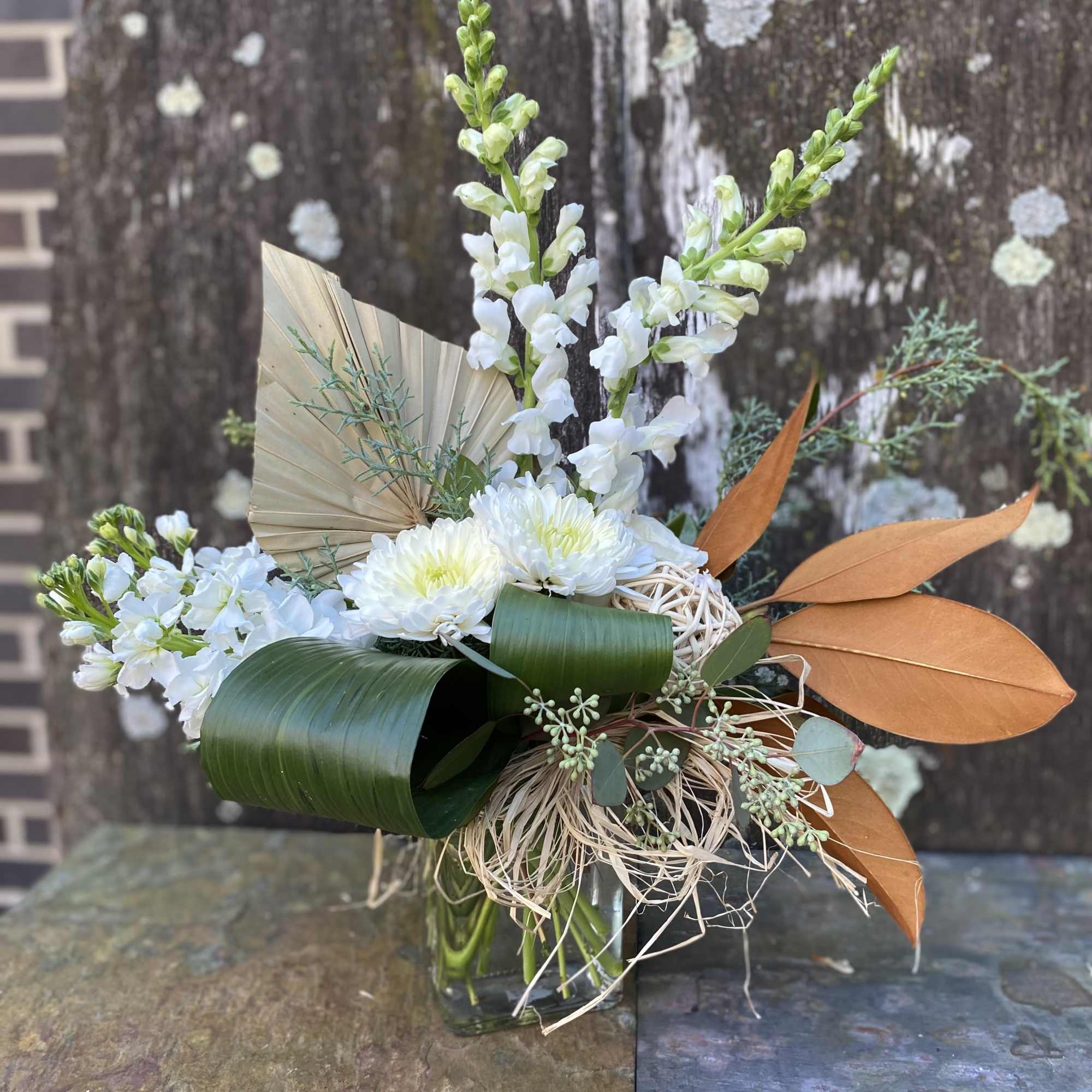 Soft tones of autumn transitioning to winter created with fresh flowers, greenery