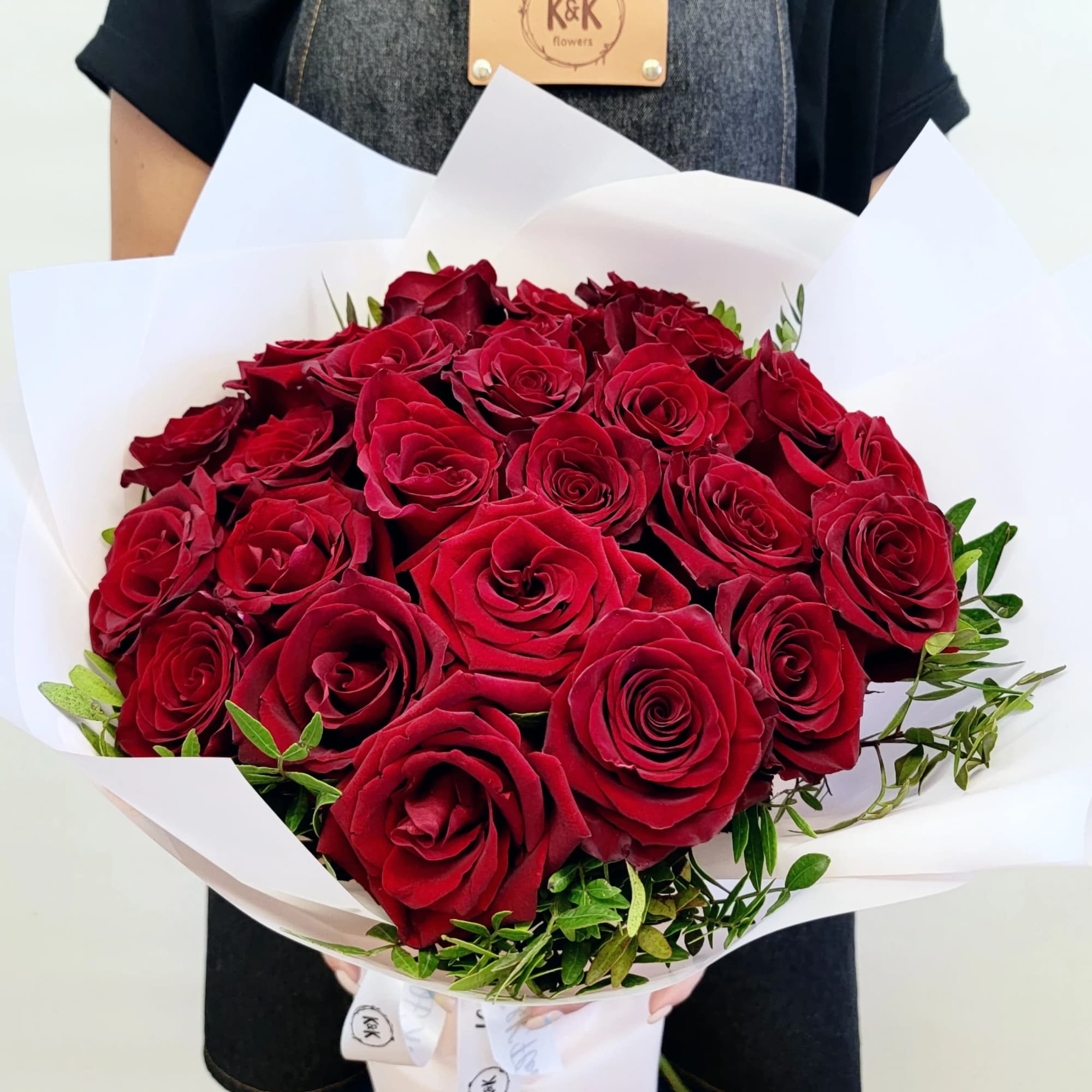 Dozen Red Roses with greenery and decorative wrapping paper. All bouquets come