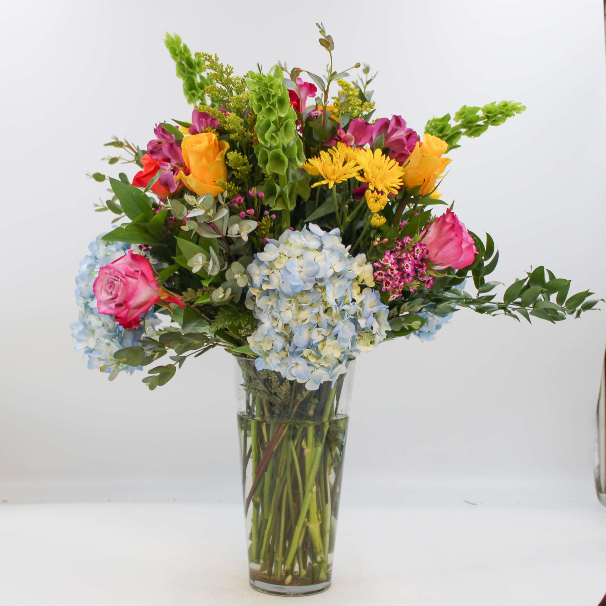 Carnival is a bright and cheery mix of Blue Hydrangea, Purple Alstromeria