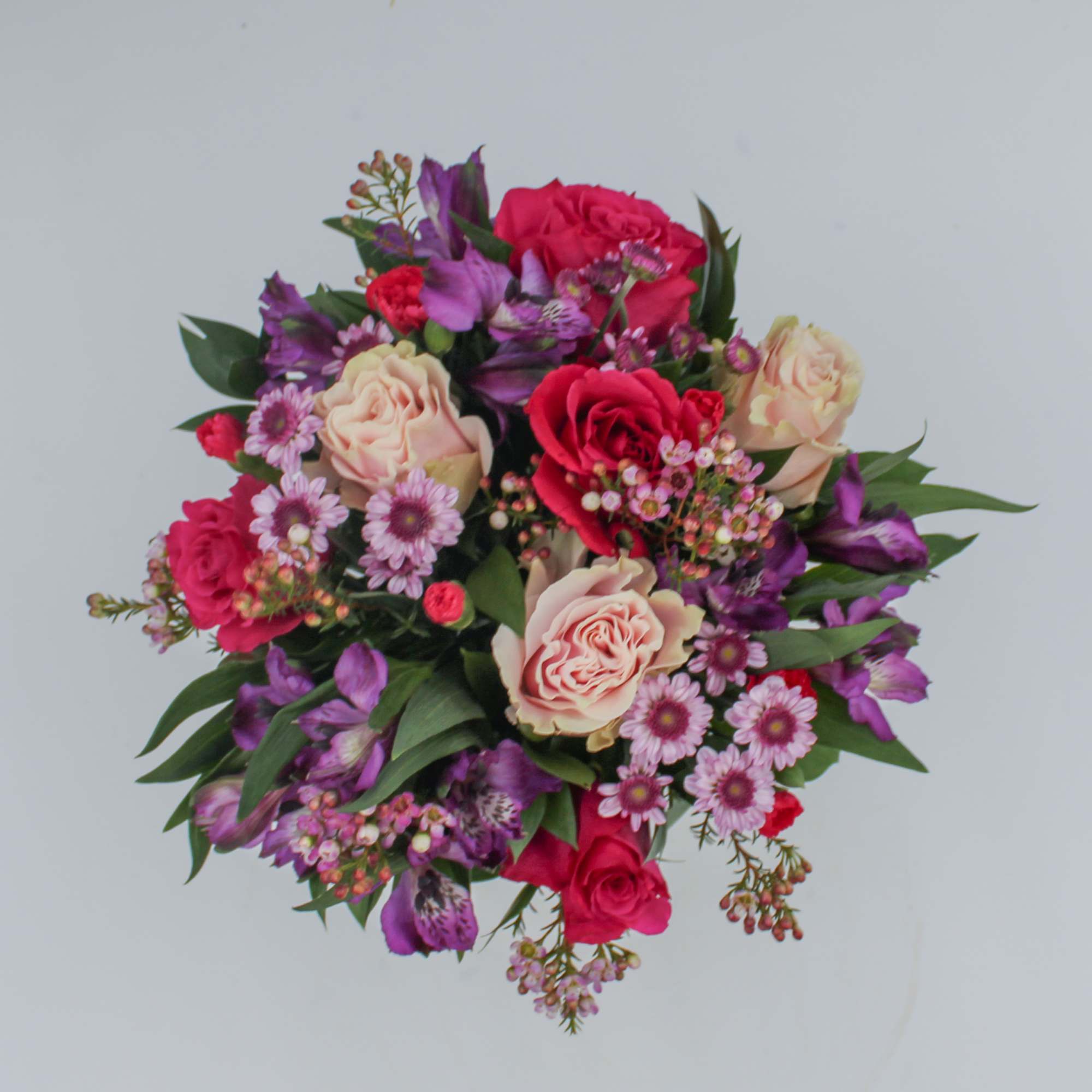 Vanessa is a colorful assortment of Purple Alstroemeria, Hot Pink Roses, Light