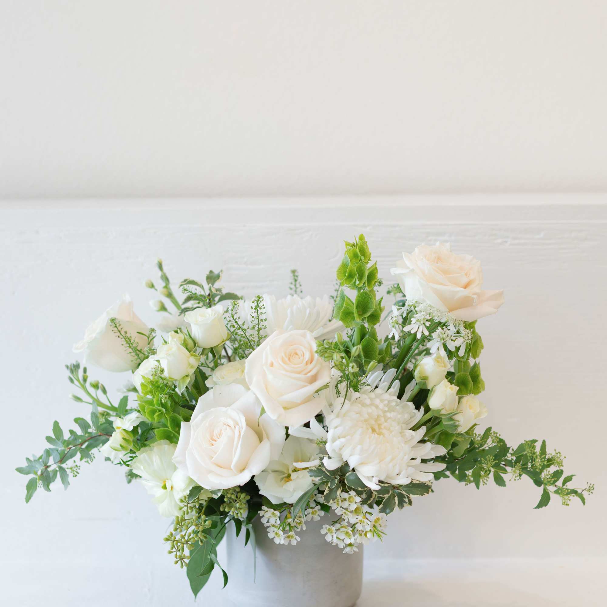 A timeless white arrangement with soft whites, airy design and natural textures.