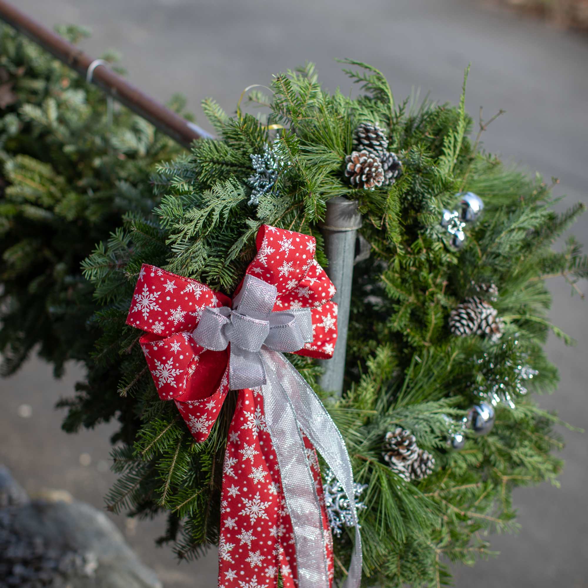 Fragrant fresh balsam wreath decorated with cones, ornaments, winter trimmings, bows, berries