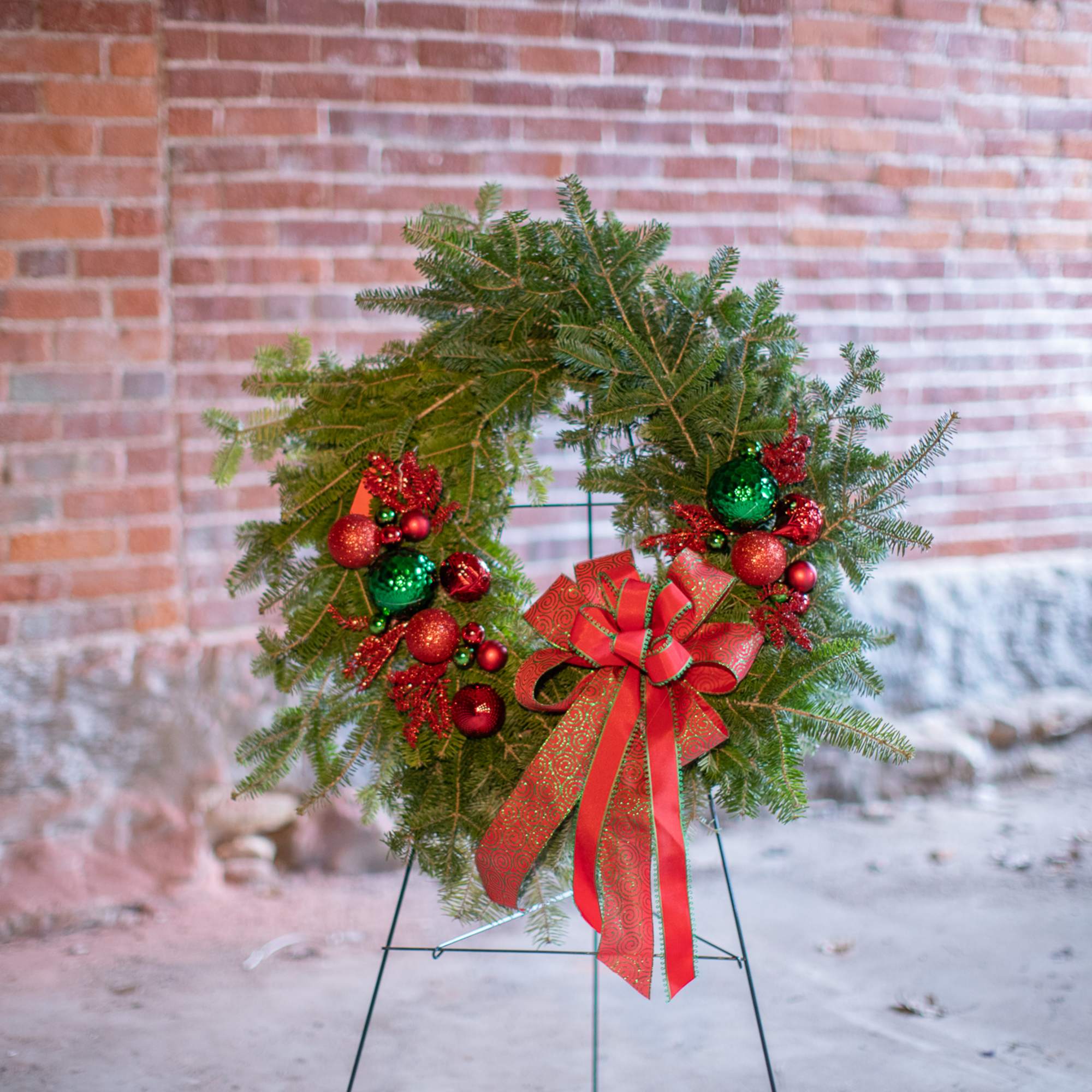 Fragrant fresh balsam wreath decorated with cones, ornaments, winter trimmings, bows, berries
