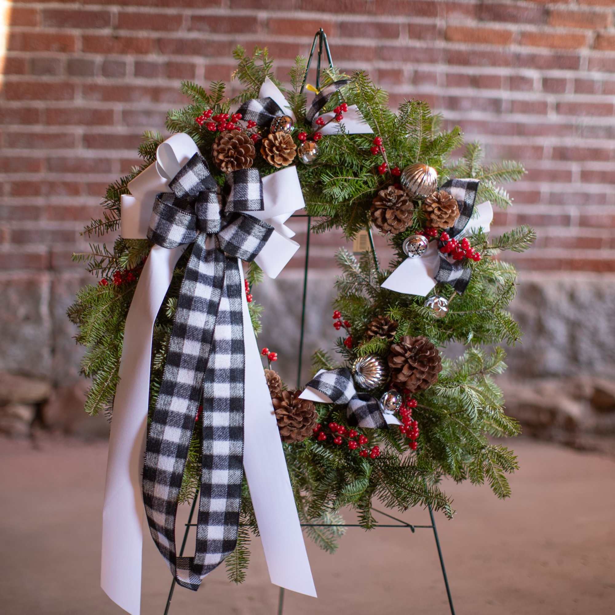 Fragrant fresh balsam wreath decorated with cones, ornaments, winter trimmings, bows, berries
