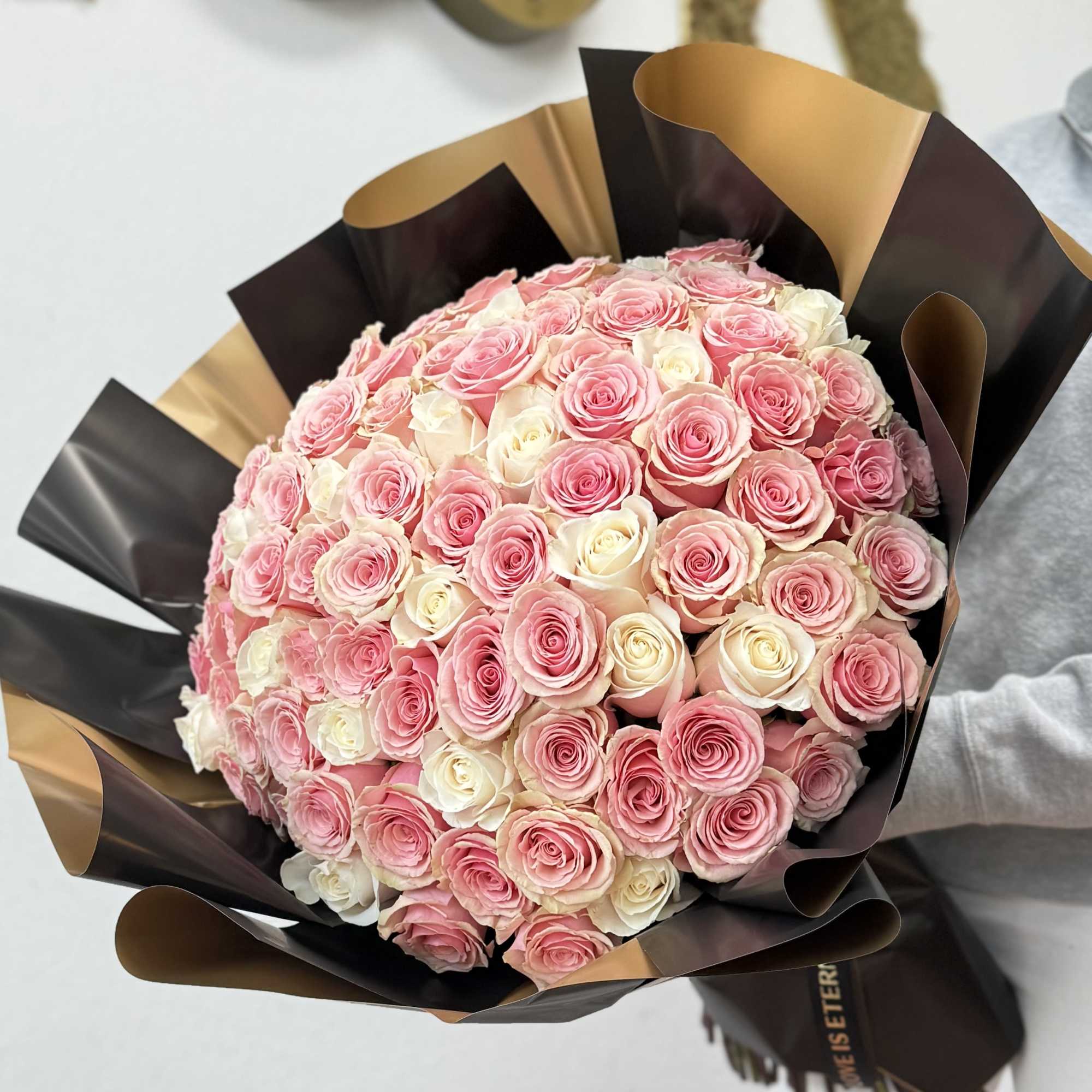 100 long-stem pink and white roses with decorative wrapping paper. One hundred