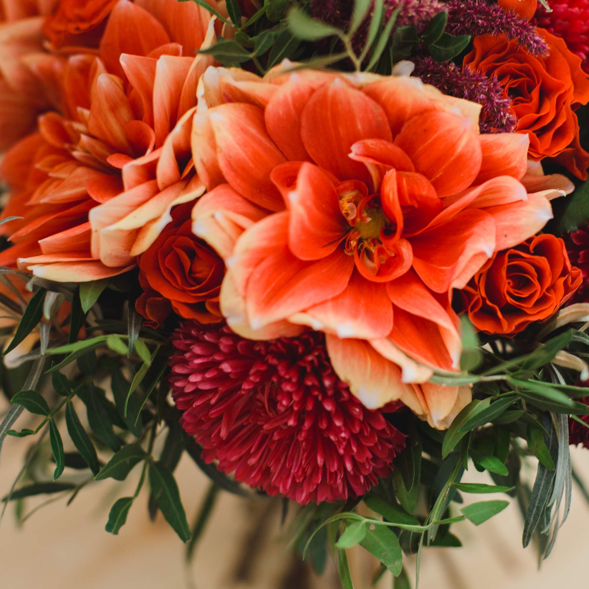 Floral arrangement in warm tones (i.e. red, orange, yellow, magenta, fuschia, etc.)