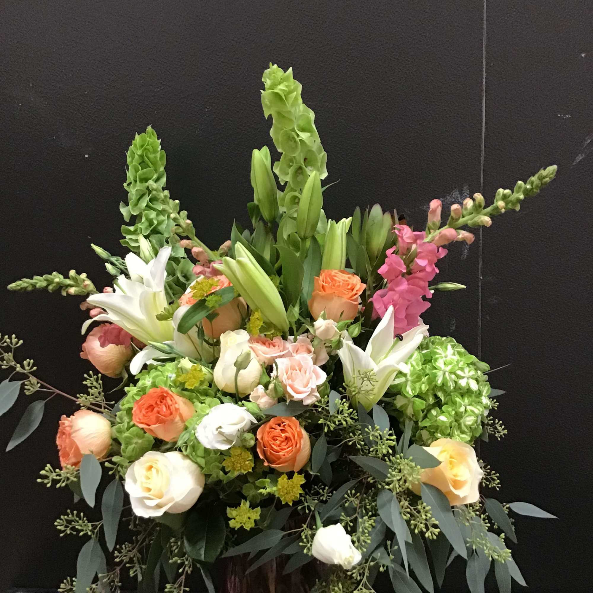 This beautiful arrangement make with peach and cream color roses, white lily