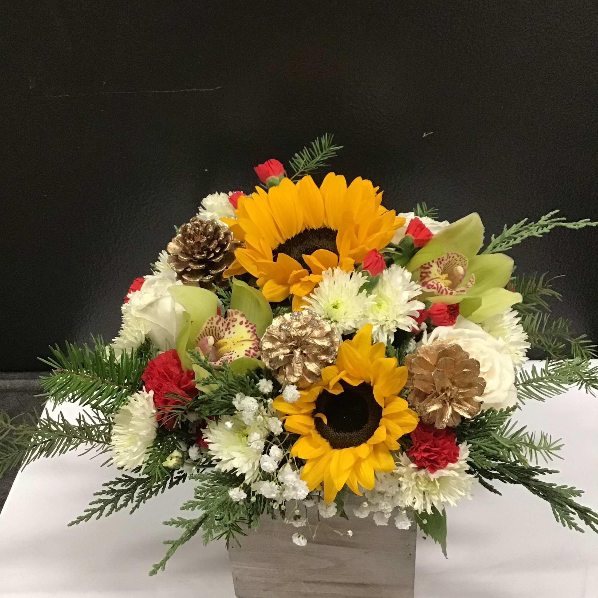 This beautiful and warm  arrangement,  made with sunflowers, roses, orchid