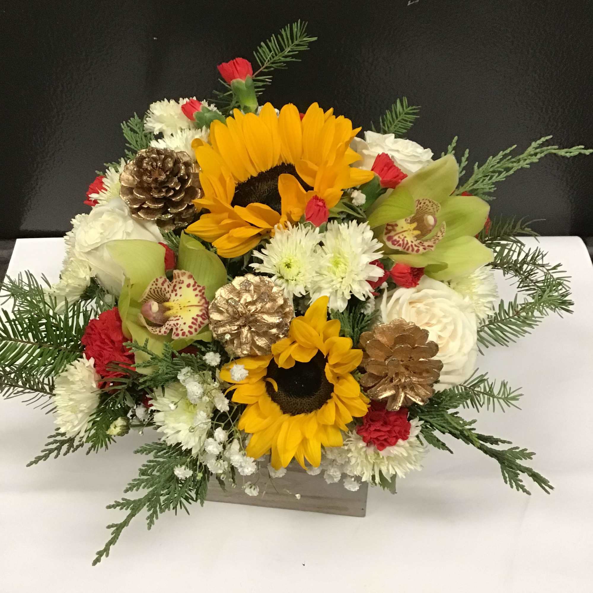 This beautiful and warm  arrangement,  made with sunflowers, roses, orchid
