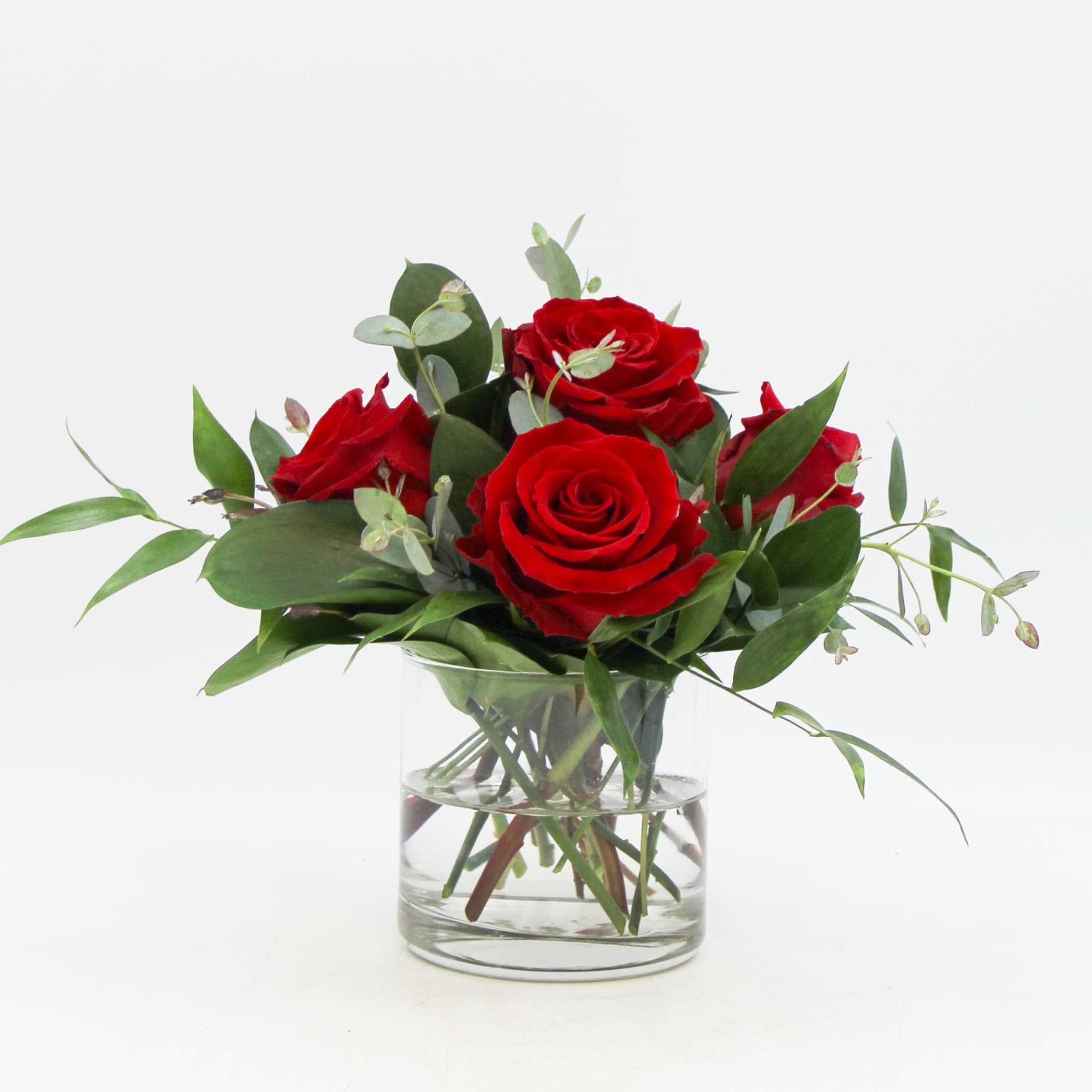 Petite Rosa is a romantic arrangement of Red Roses and seasonal foliage.