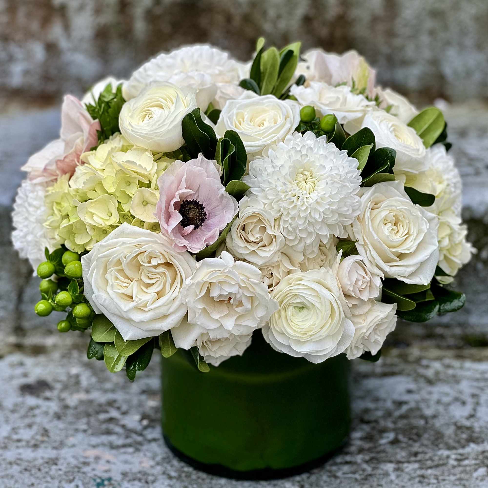 A modern, hand tied compact styled arrangement of our white blooms from