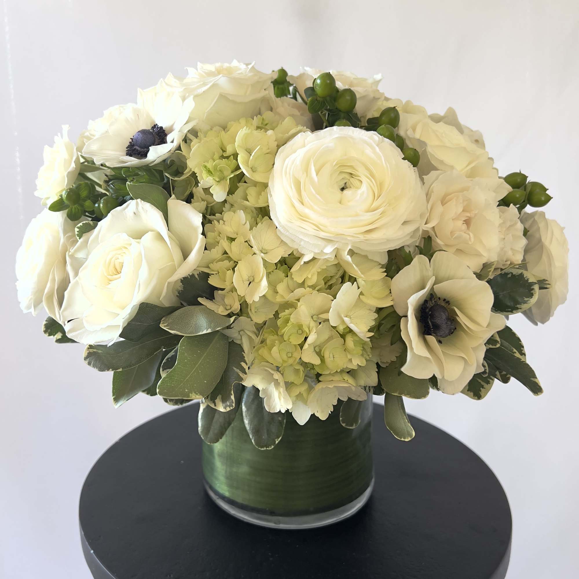 A modern, hand tied compact styled arrangement of our white blooms from