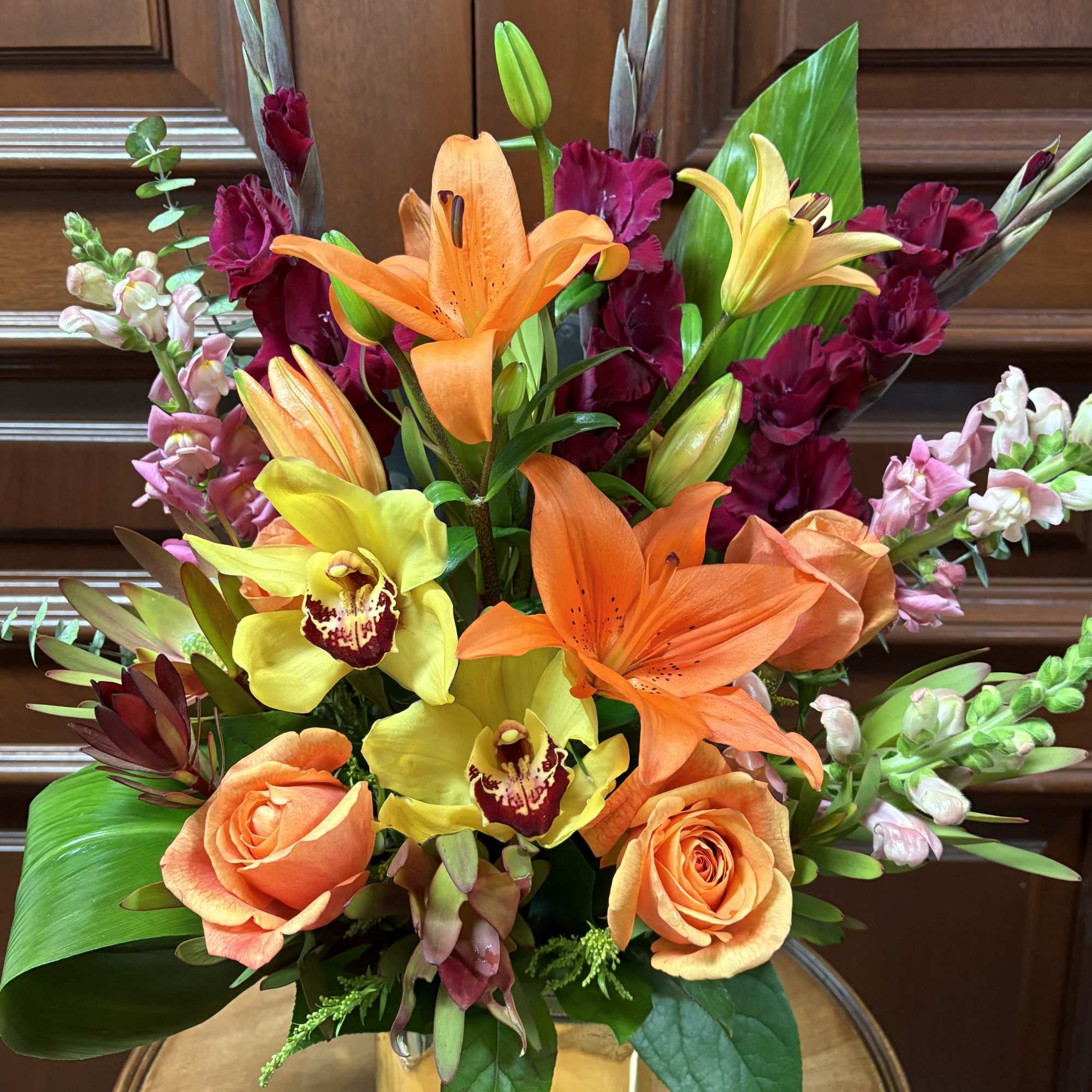 A beautiful safarian sunset with Orange Lilies, Cream Roses, Snapdragons, Gladiolas, and