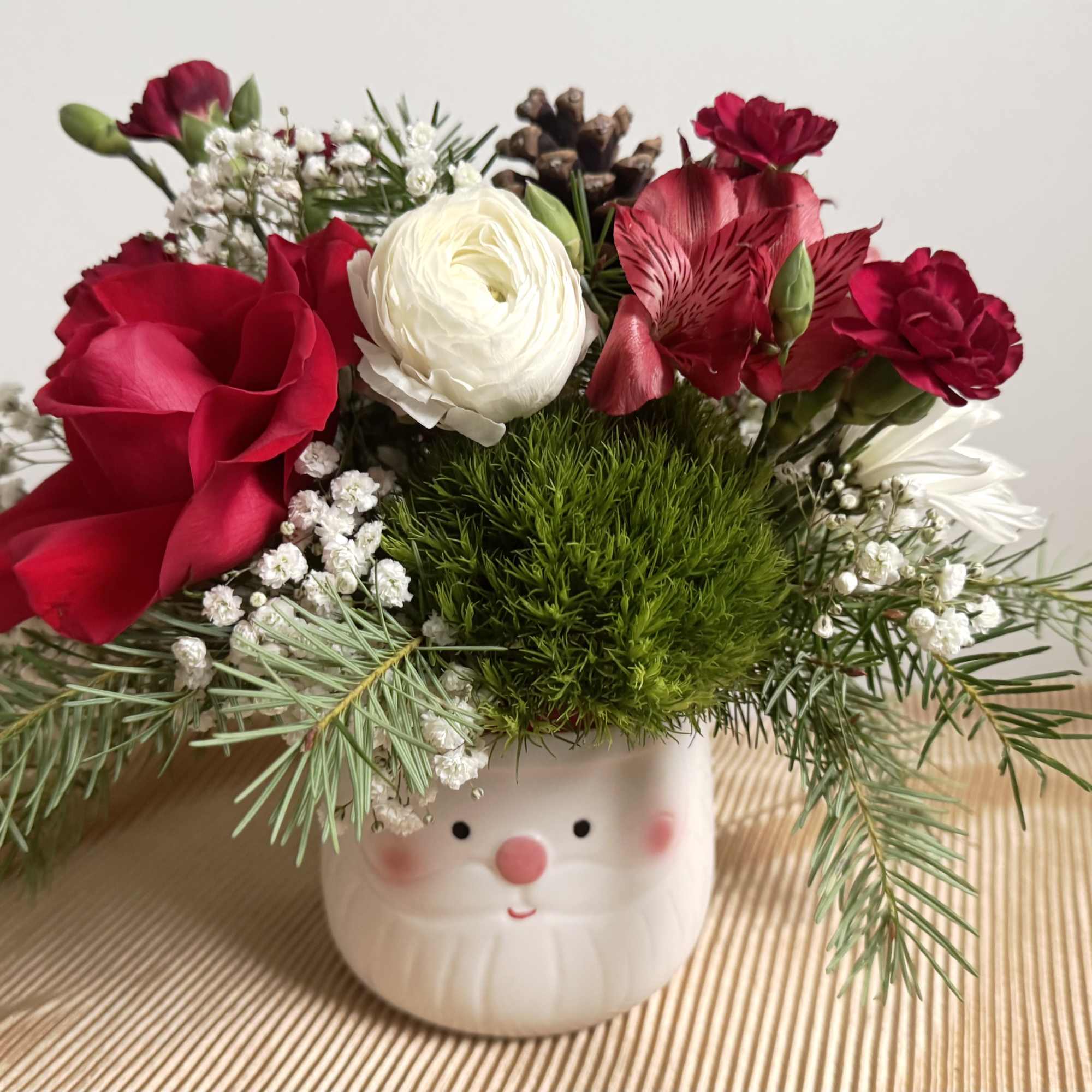 Send some holiday cheer with our Santa Baby flower arrangement. Seasonal premium