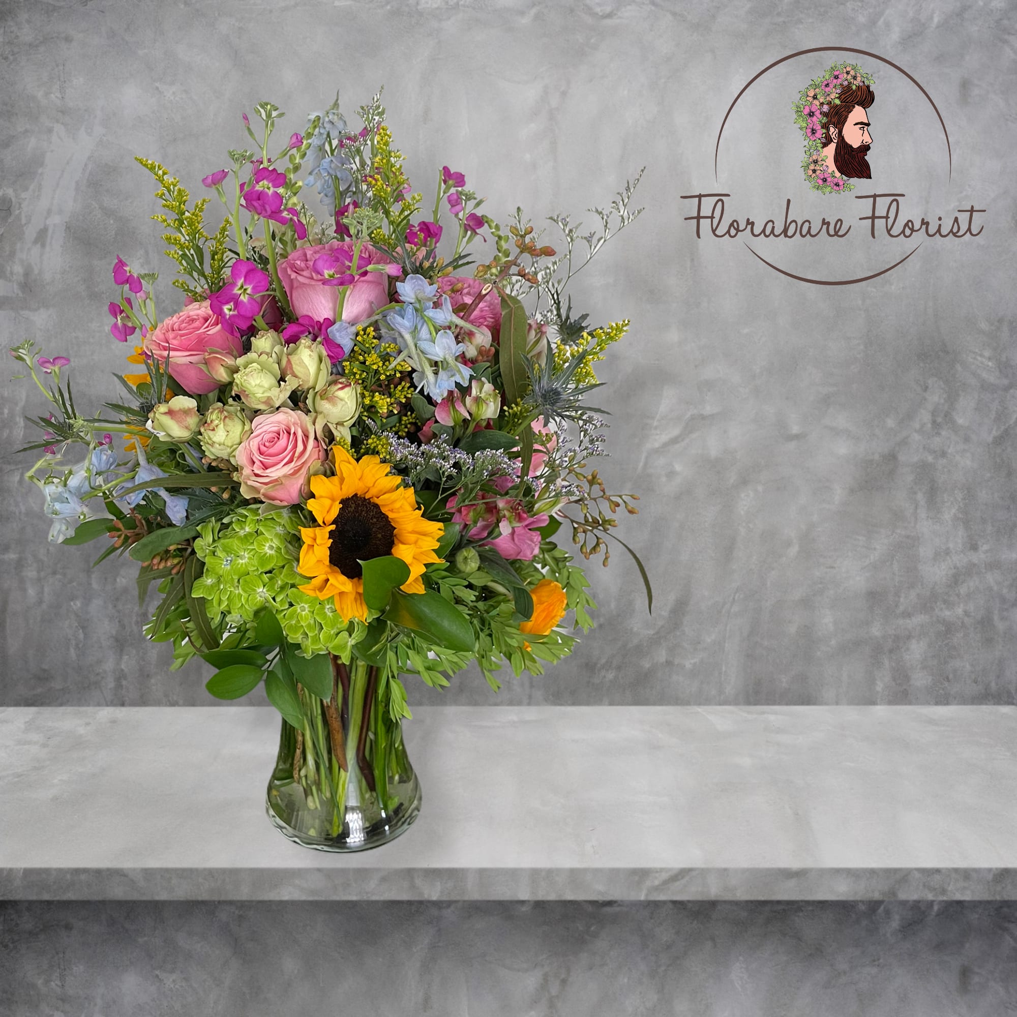 Lush floral design filled with vibrant colors. Consisting of seasonal flowers and