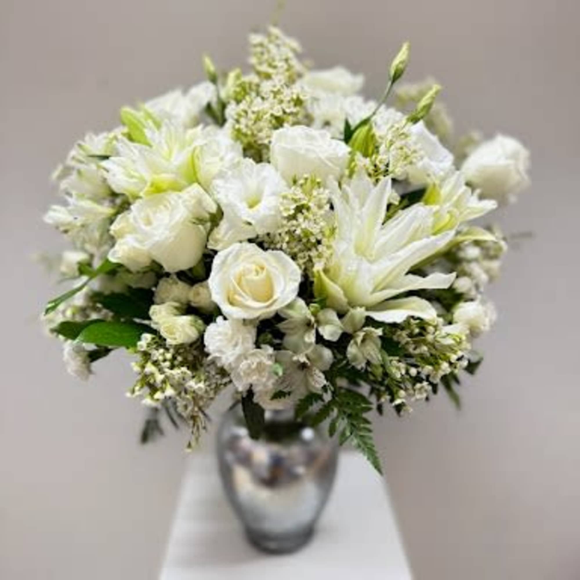 A timeless masterpiece of purity and grace. This elegant arrangement features premium