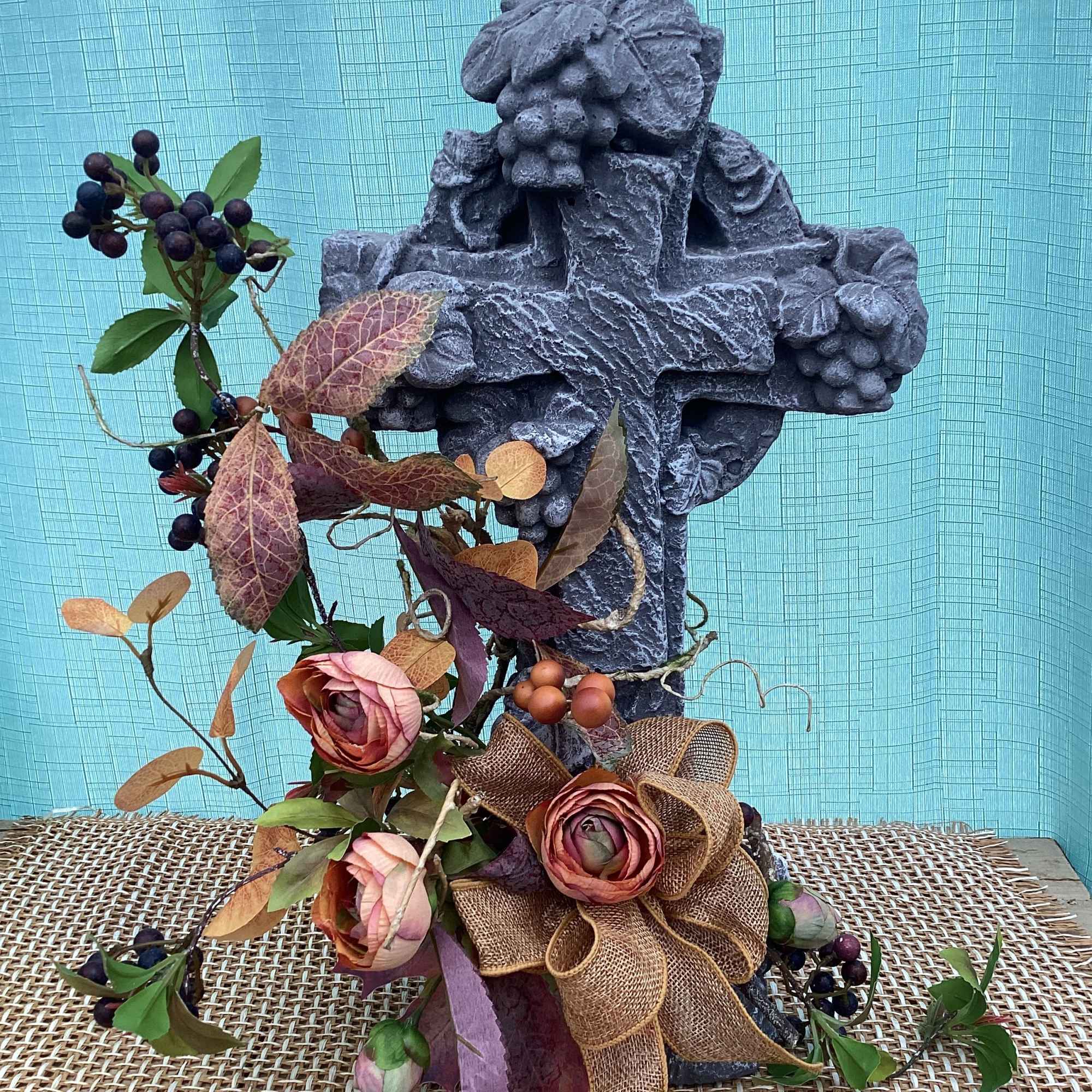 A lovely cross with vines to decorate a yard.
