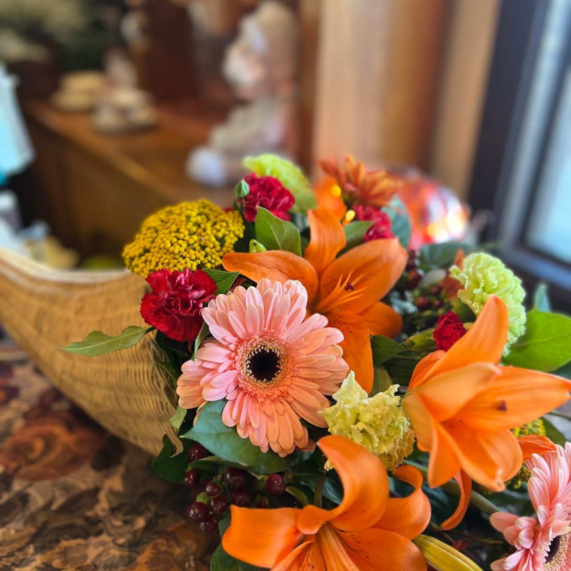 Orange asiatic lilies paired with soft pink gerber daisies, green carnations, yarrow